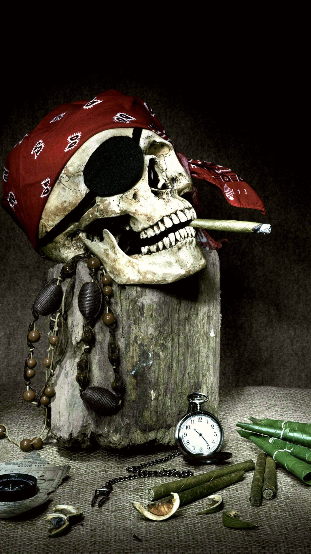 Pirate skull wearing a red bandana and eyepatch with a cigar in its teeth next to an antique pocket watch.