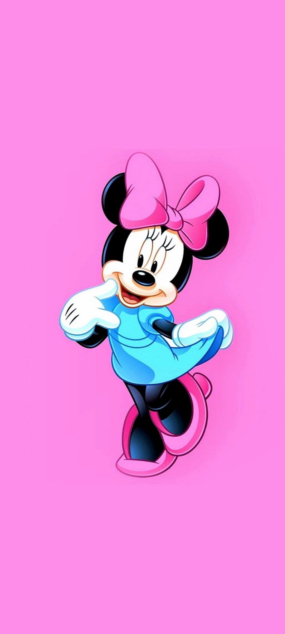 Minnie Mouse wearing a bright blue dress and pink bow poses playfully against a solid vibrant pink background.