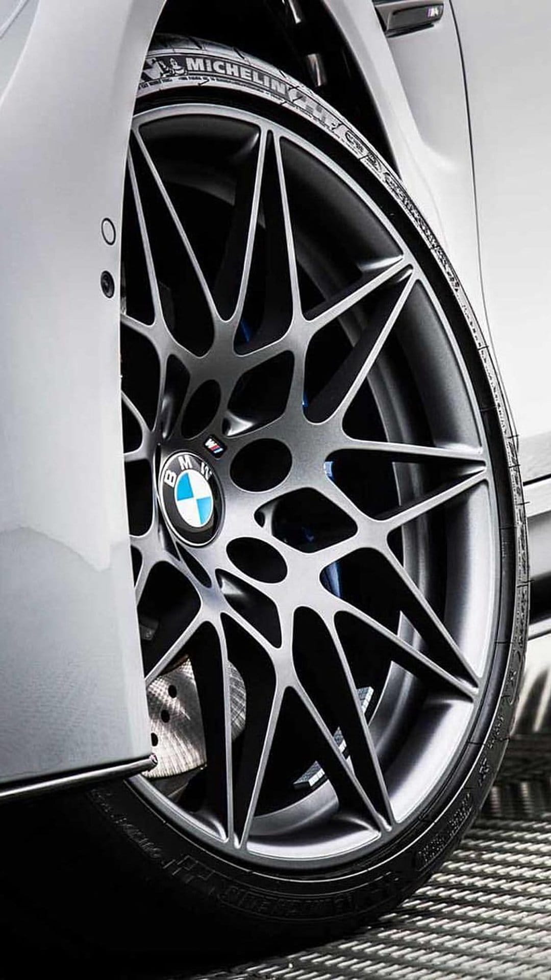 BMW M sport alloy wheel features silver multi-spoke rims, Michelin tire lettering, and a metallic brake caliper.