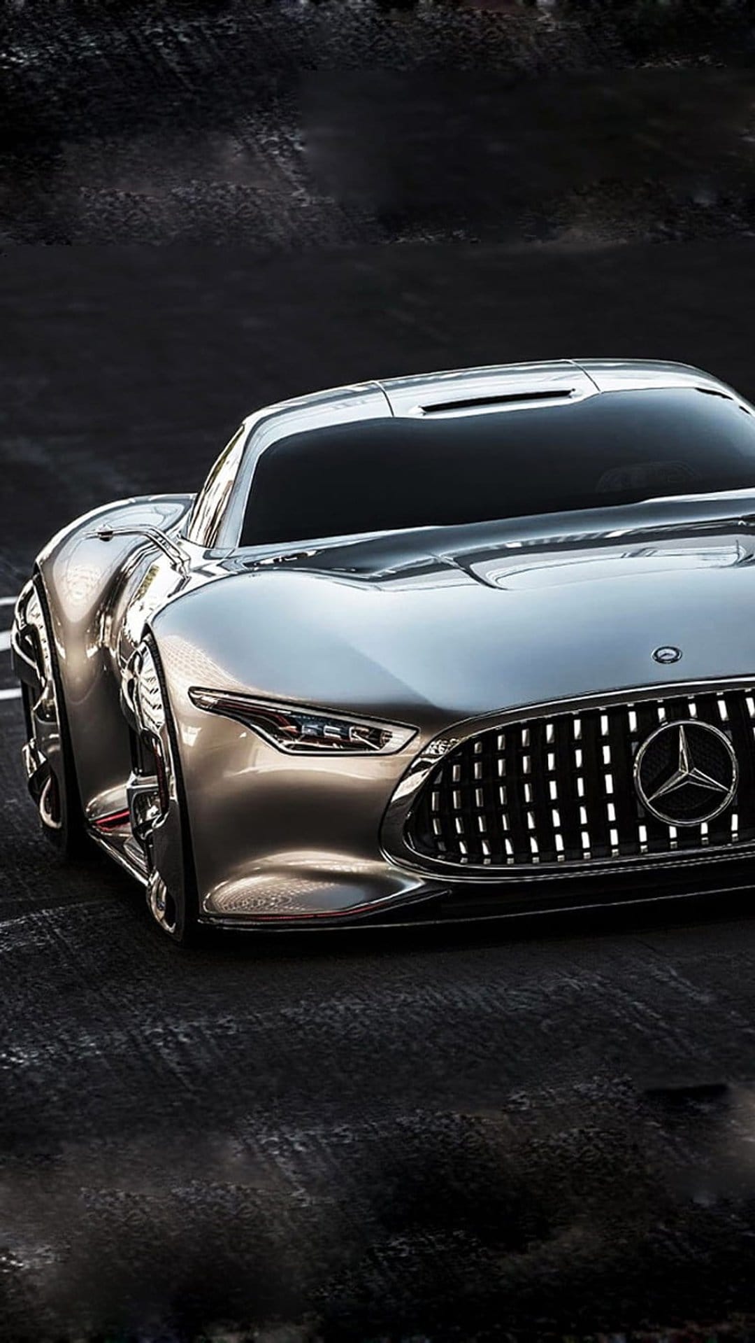 Mercedes-AMG Vision GT concept car features a silver metallic finish, bright LED headlights, and a mesh grille.