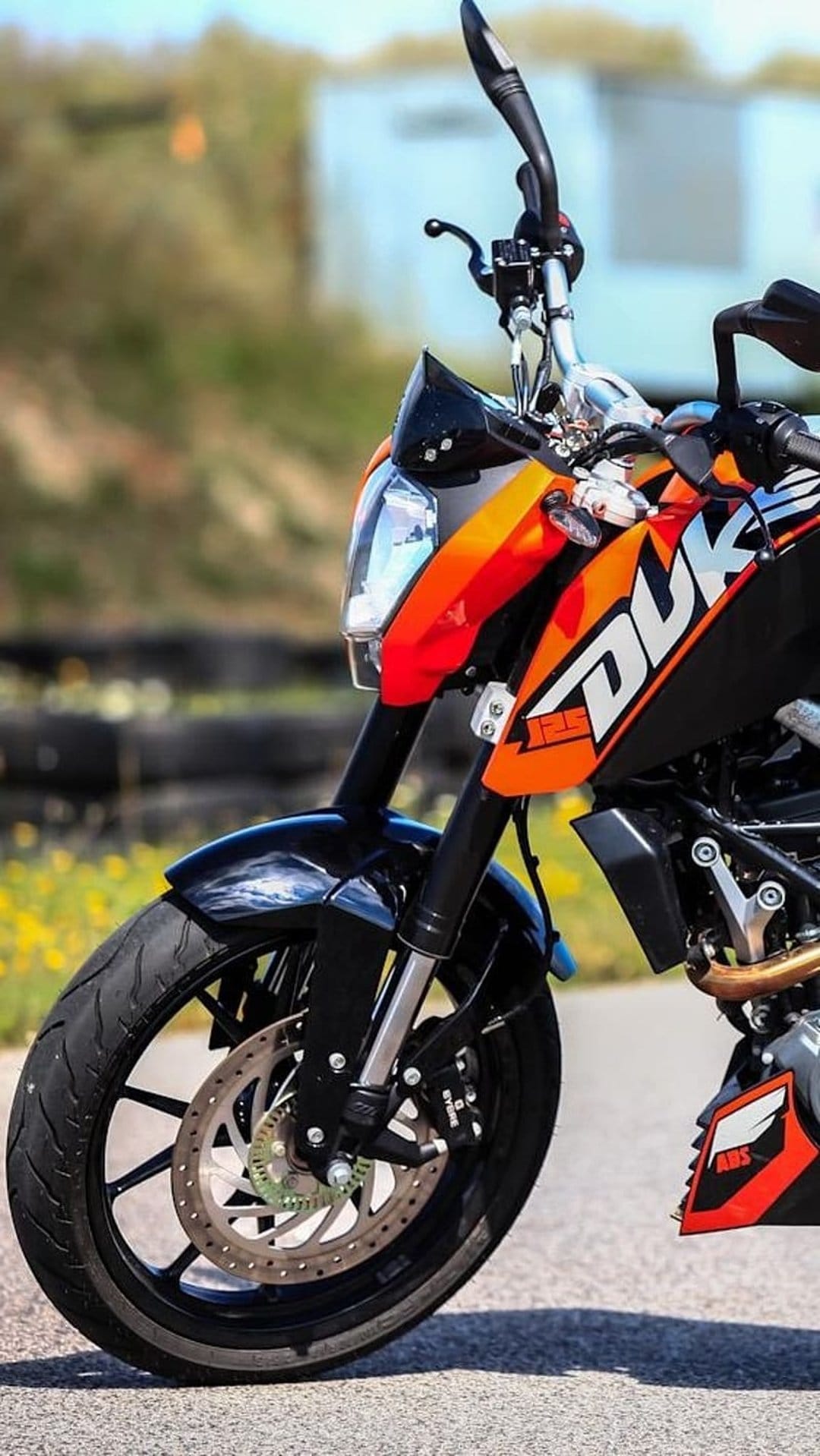KTM Duke front wheel with a ventilated brake disc and orange fairing detail showing mechanical components.