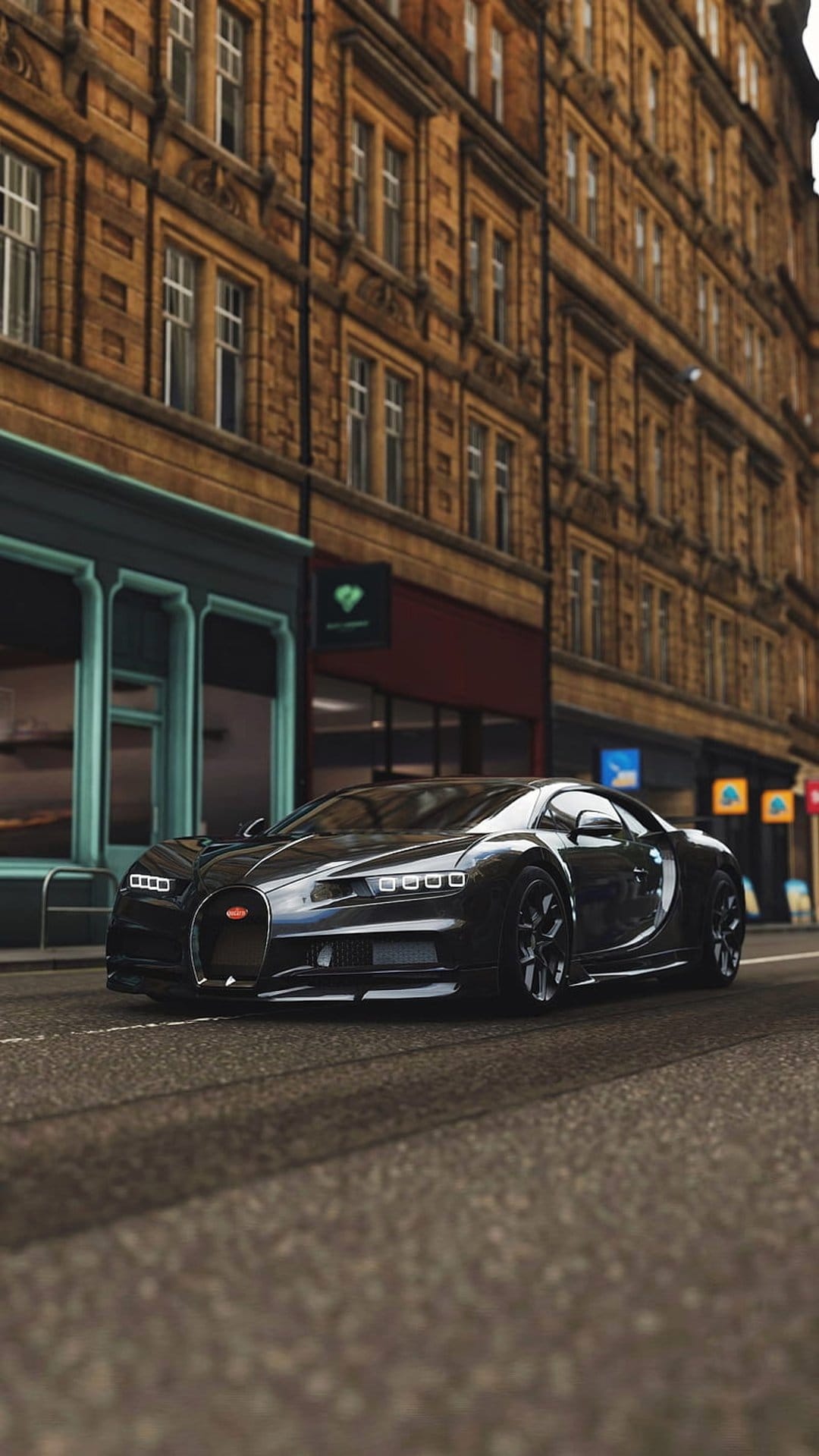 Black Bugatti Chiron hypercar parked on a narrow cobblestone street surrounded by classic European stone buildings.