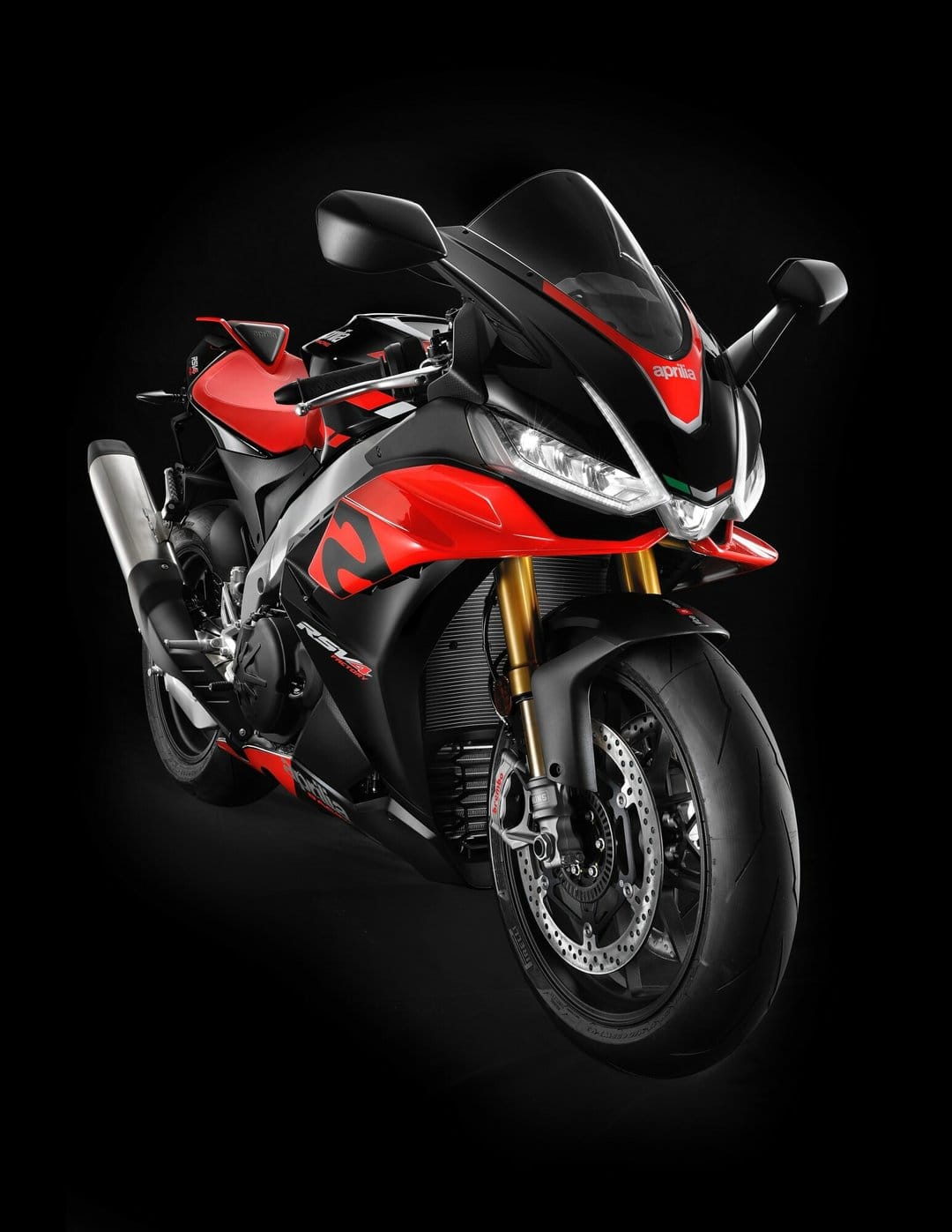 Front view of a red and black Aprilia RSV4 Factory motorcycle with LED lights on against a black background.