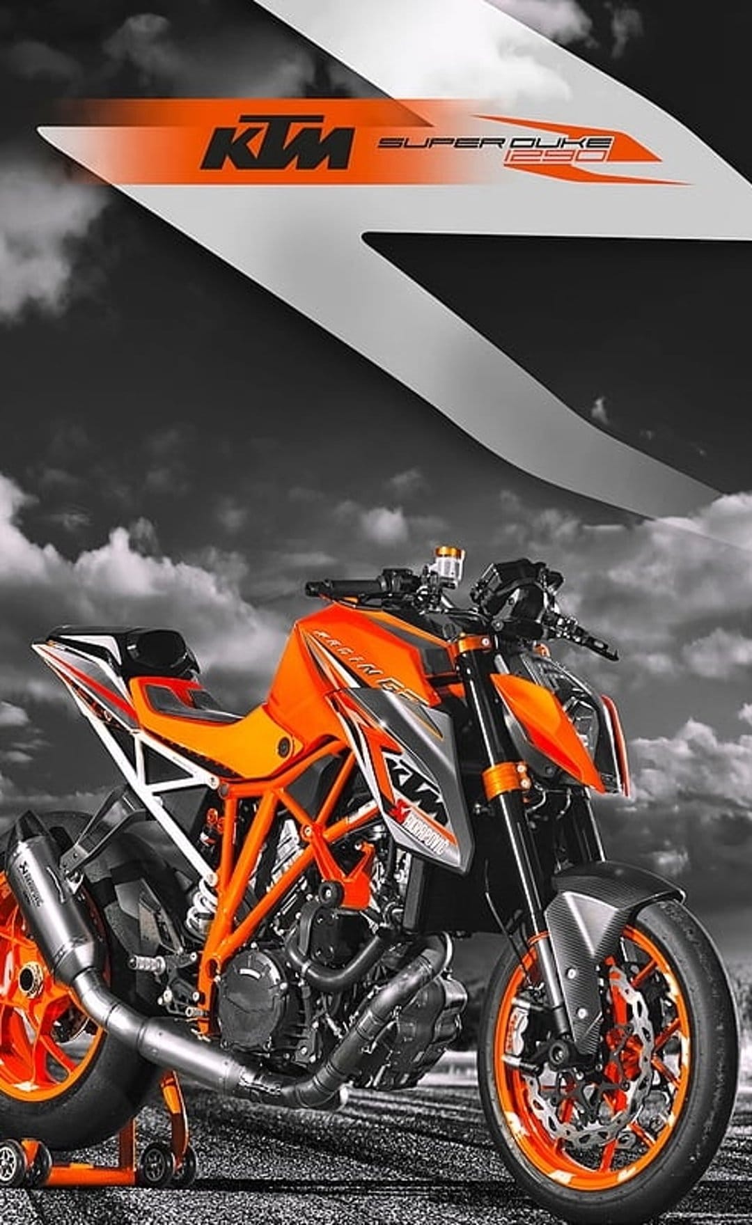 KTM Super Duke 250 motorcycle with orange accents on a paddock stand against a dramatic black and white cloudy sky.