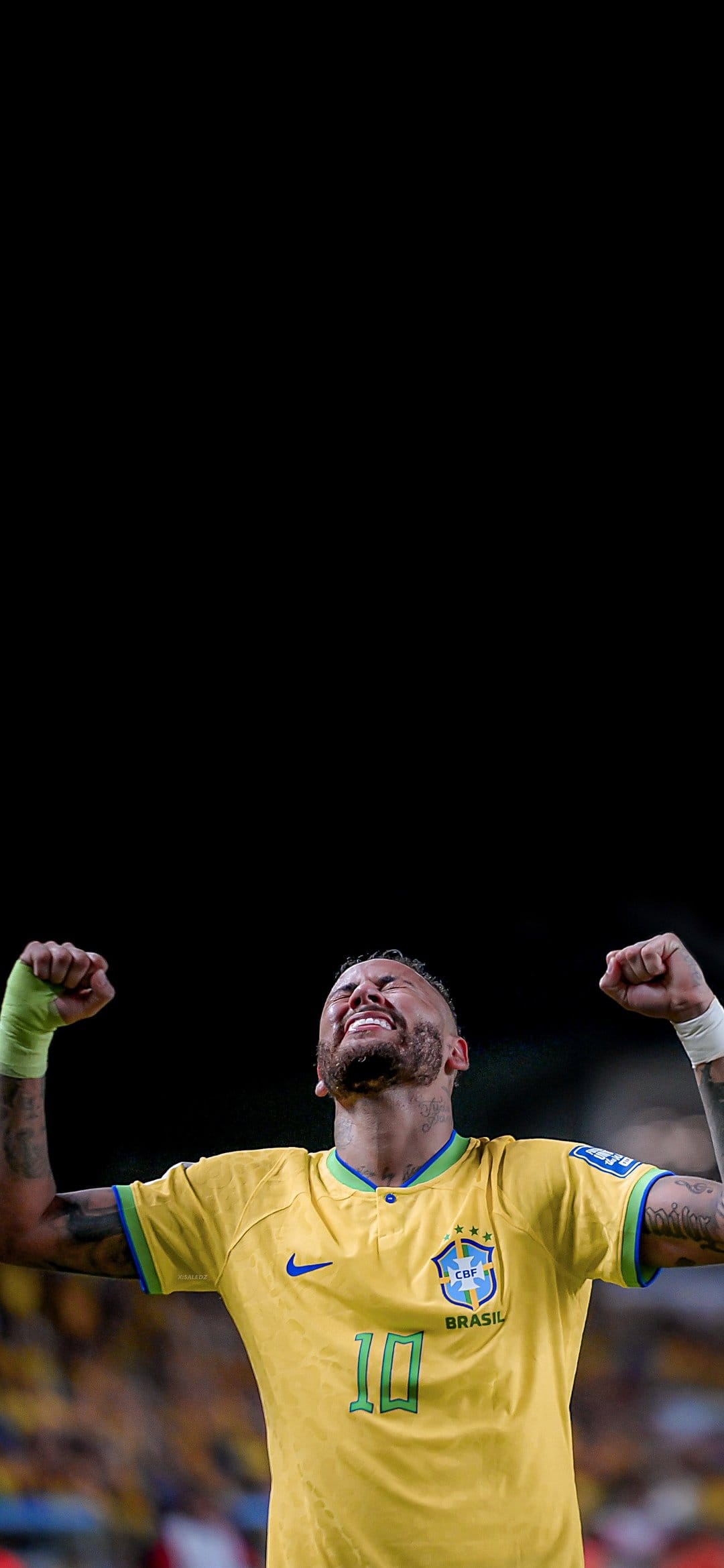 Neymar Jr raises his arms with closed eyes wearing a yellow Brazil soccer jersey number 10 during a celebration.
