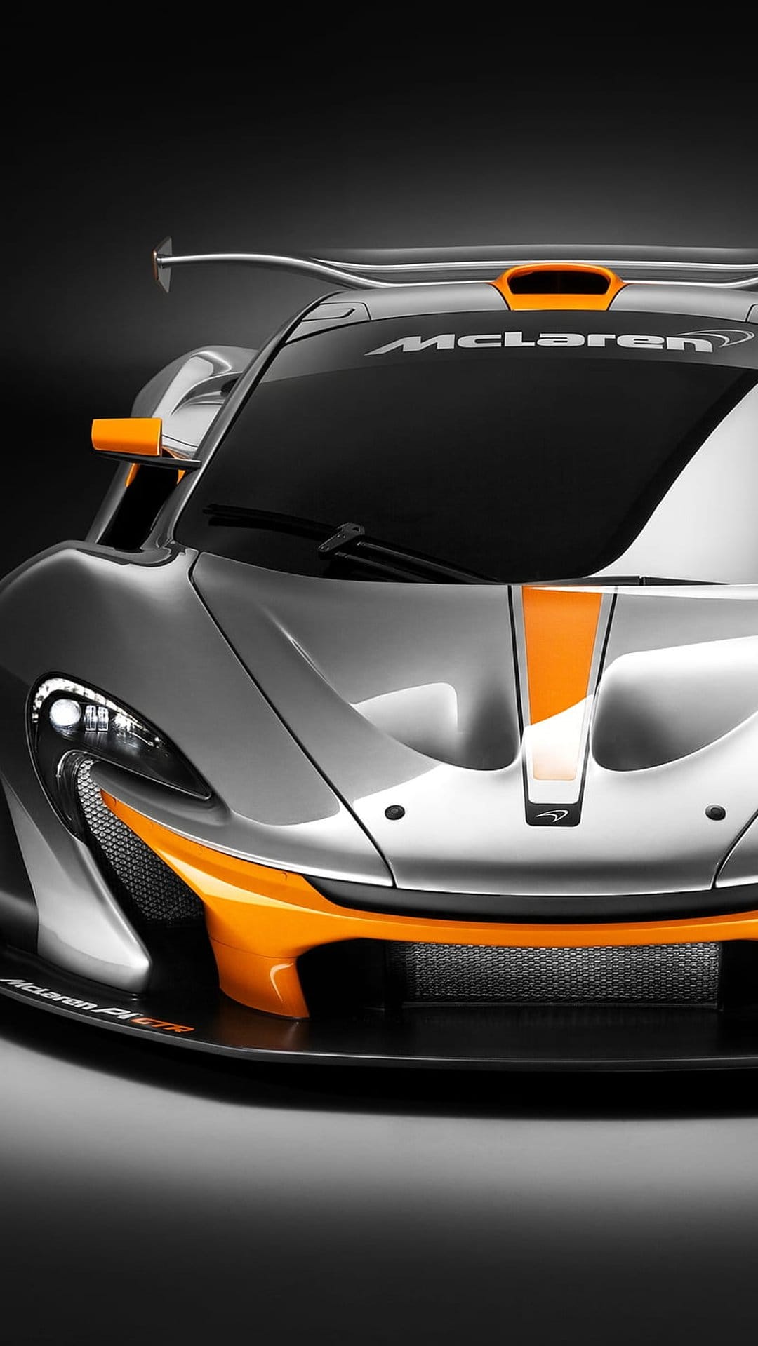 McLaren P1 GTR supercar with silver paint and orange racing stripes viewed from the front at close range.