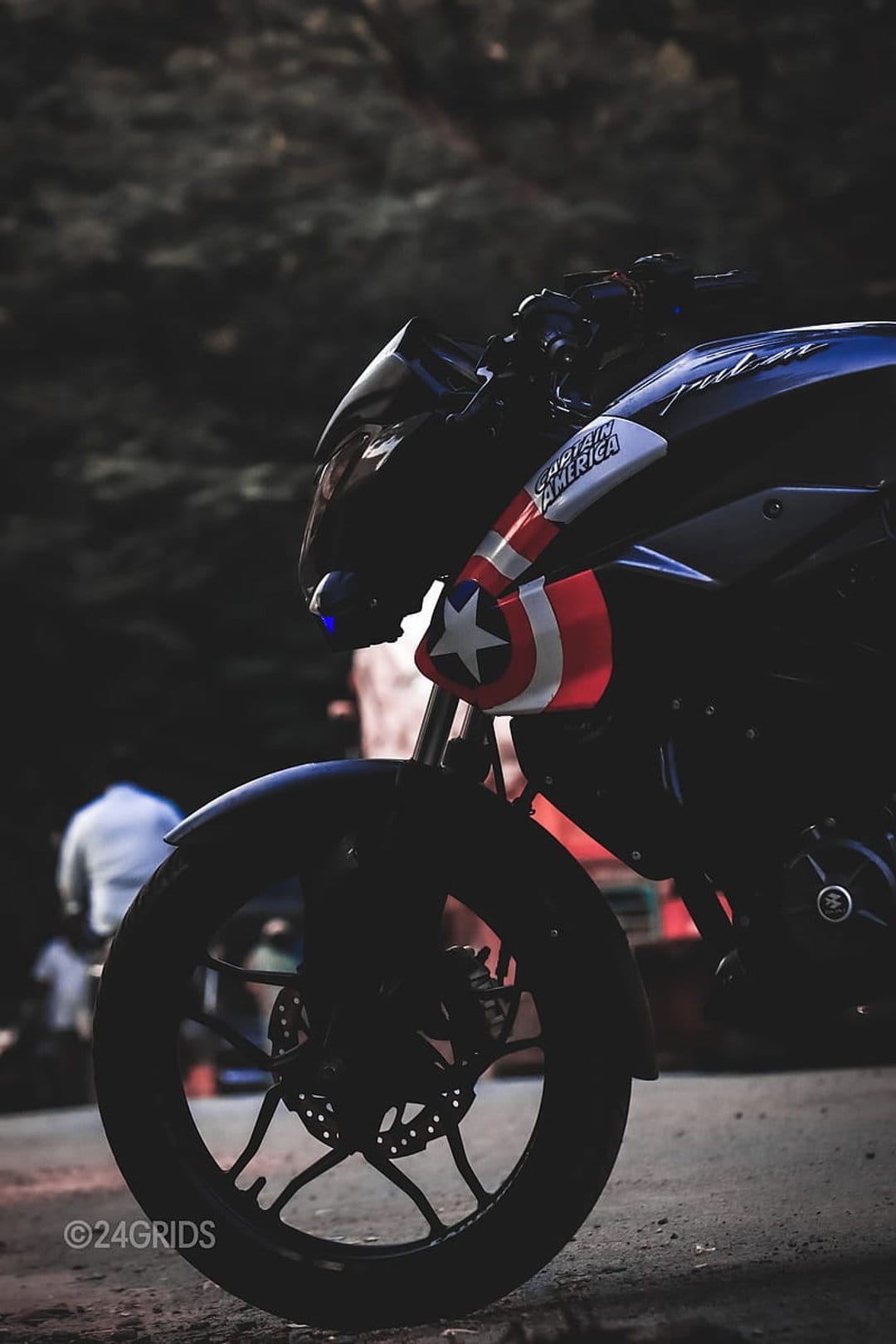 Captain America motorcycle fairing with a white star and red stripes above a chrome disc brake and tire.