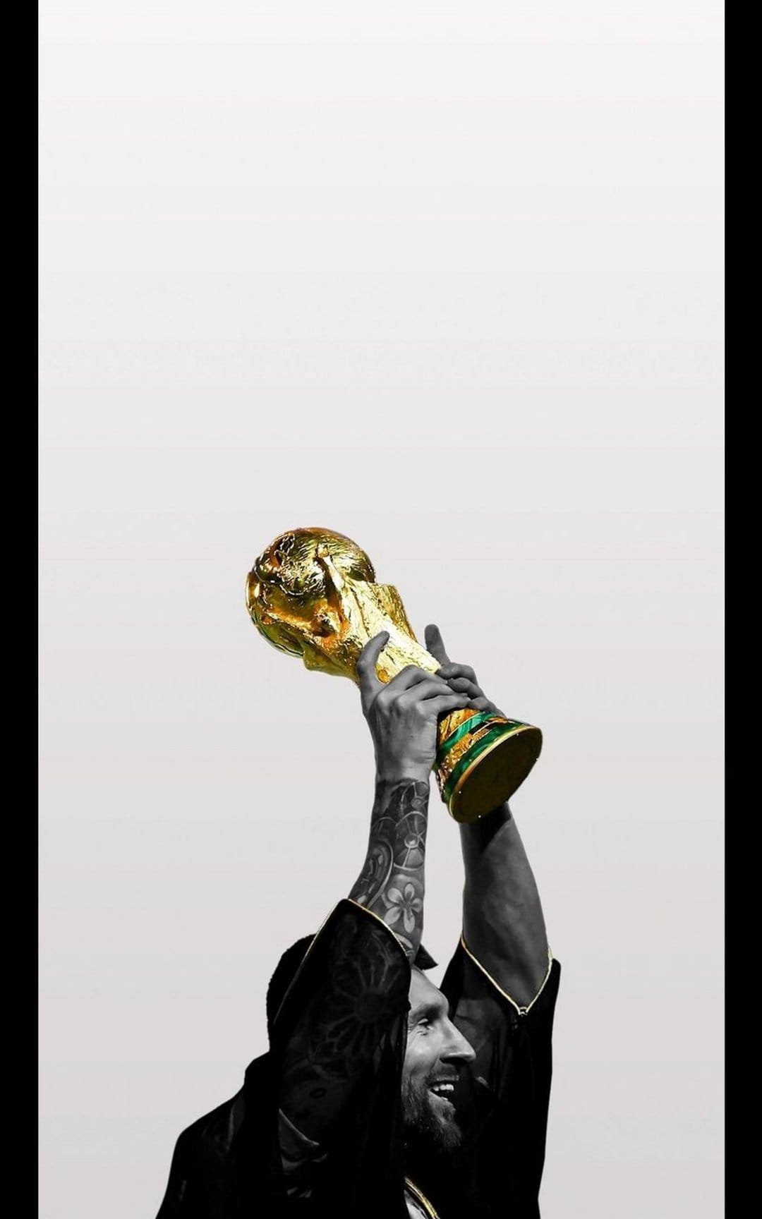 Lionel Messi holds the gold World Cup trophy high against a minimalist grey background showing arm tattoos.