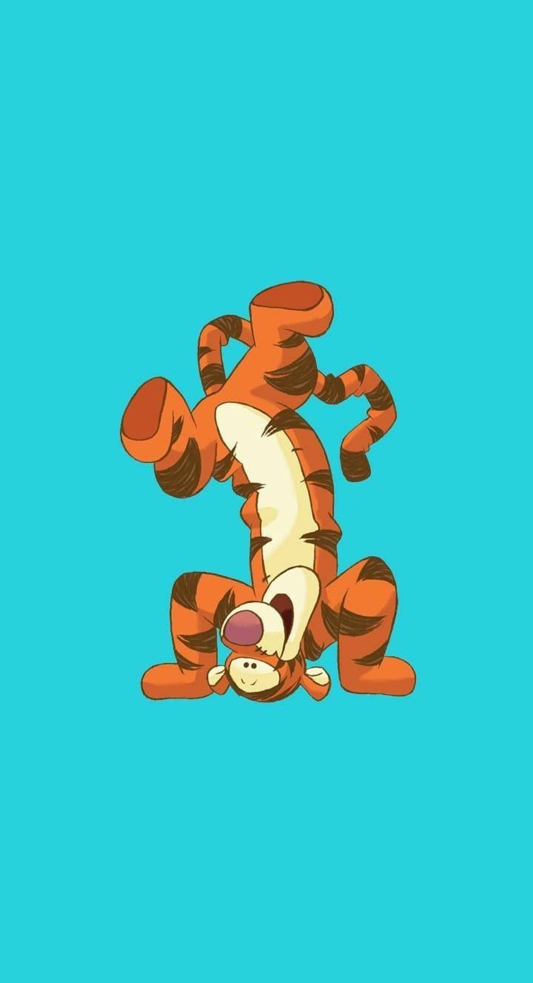 Tigger balances on his head with a joyful smile and coiled tail against a solid turquoise studio background.