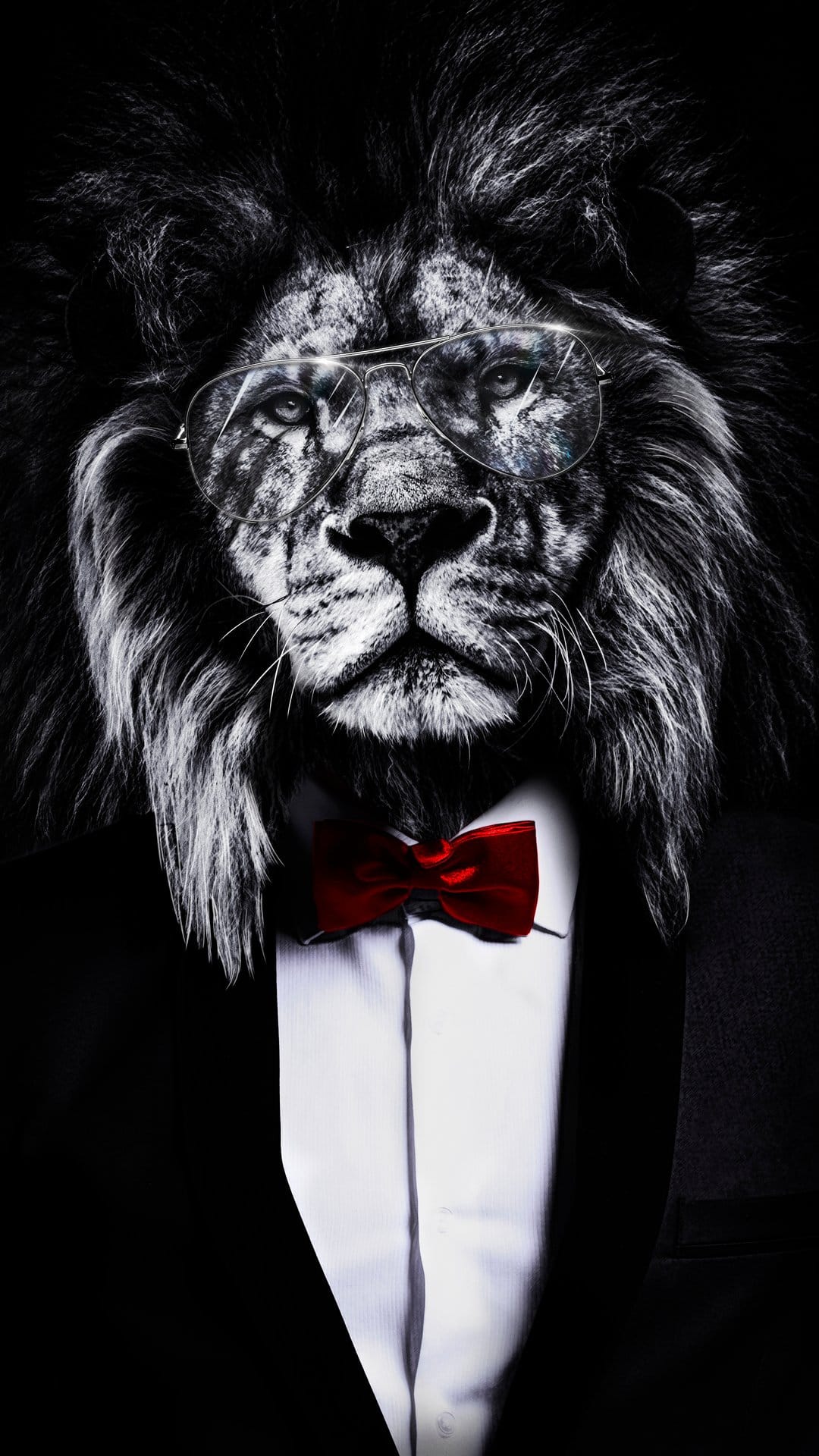 Lion wearing a black tuxedo, red bow tie, and aviator glasses in a dramatic black and white portrait setting.