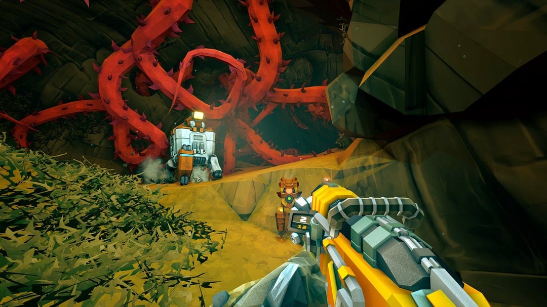 First-person view of a yellow weapon in a rocky cave with glowing red thorny vines and robotic drones.