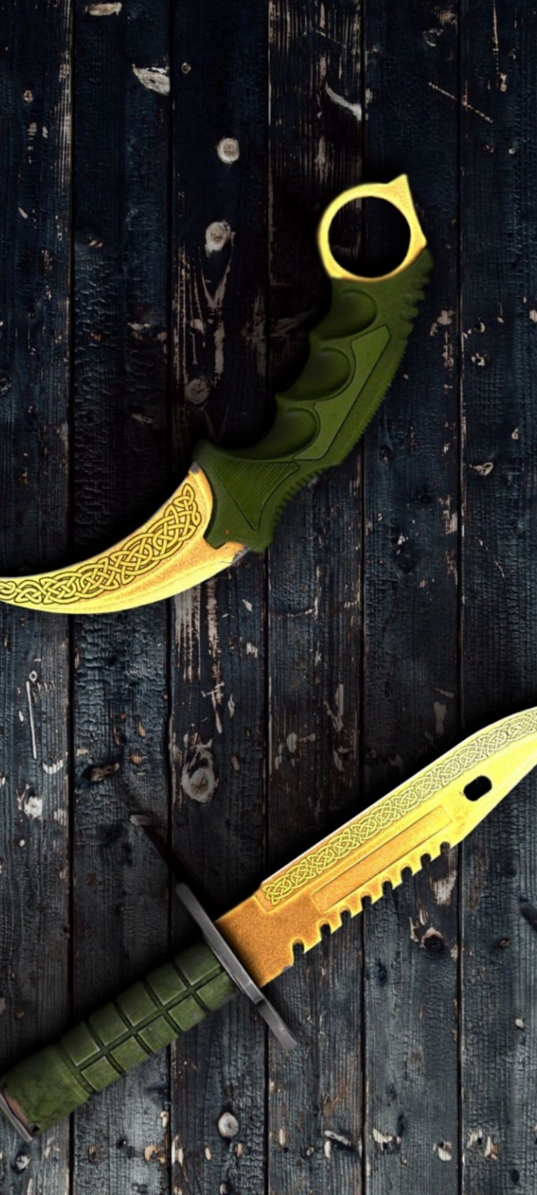 Golden karambit and combat knife with green handles on dark wood planks in a vertical close-up composition.