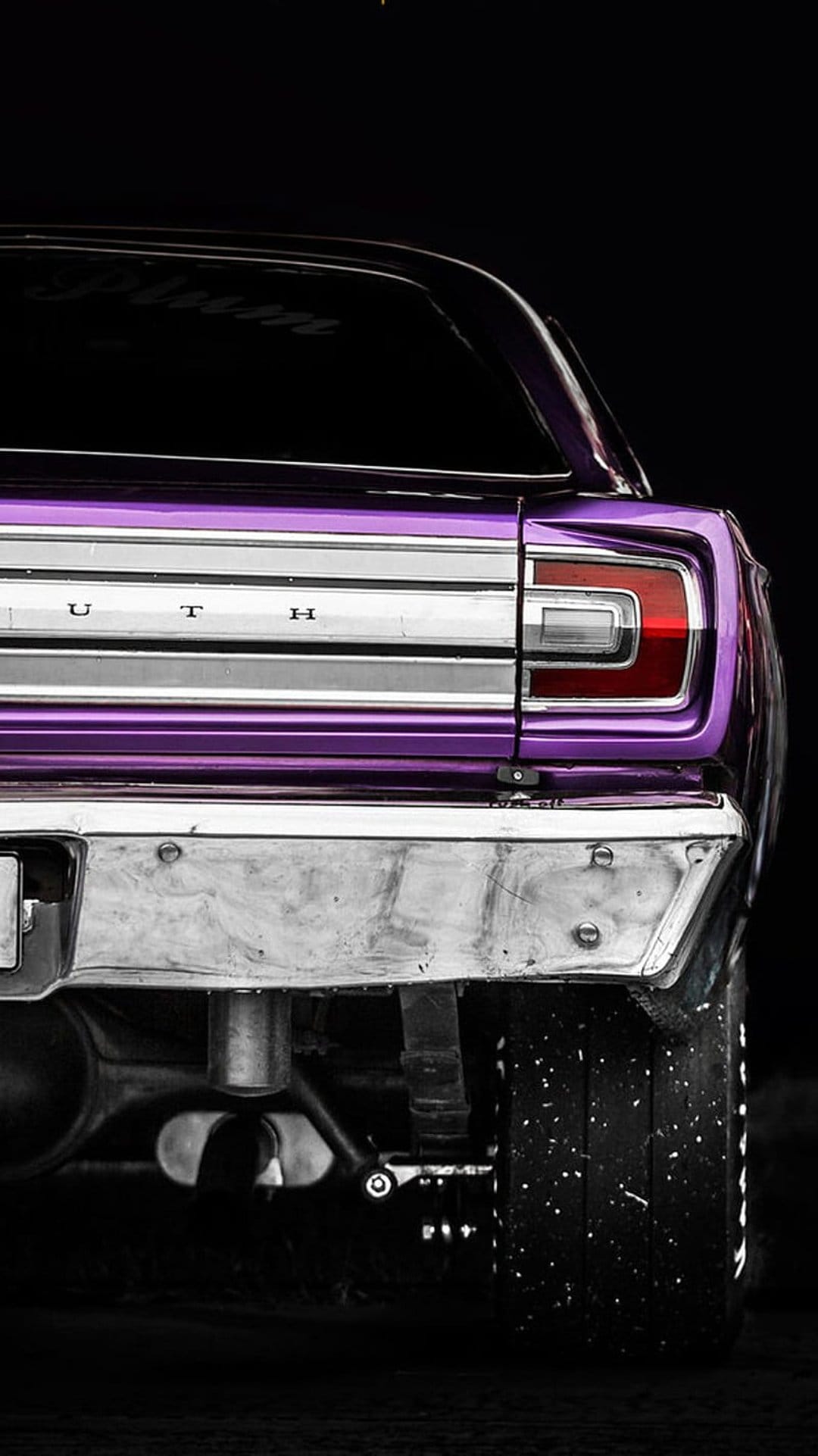 Purple Plymouth Barracuda rear bumper and tail lights featuring chrome badging and a dusty wide racing tire.
