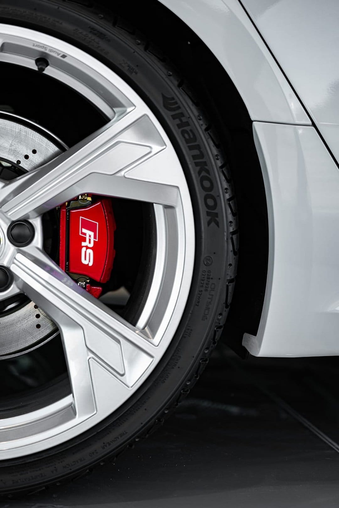 Red RS brake caliper behind silver multi-spoke alloy rims and a Hankook Ventus tire on a sleek silver sports car.