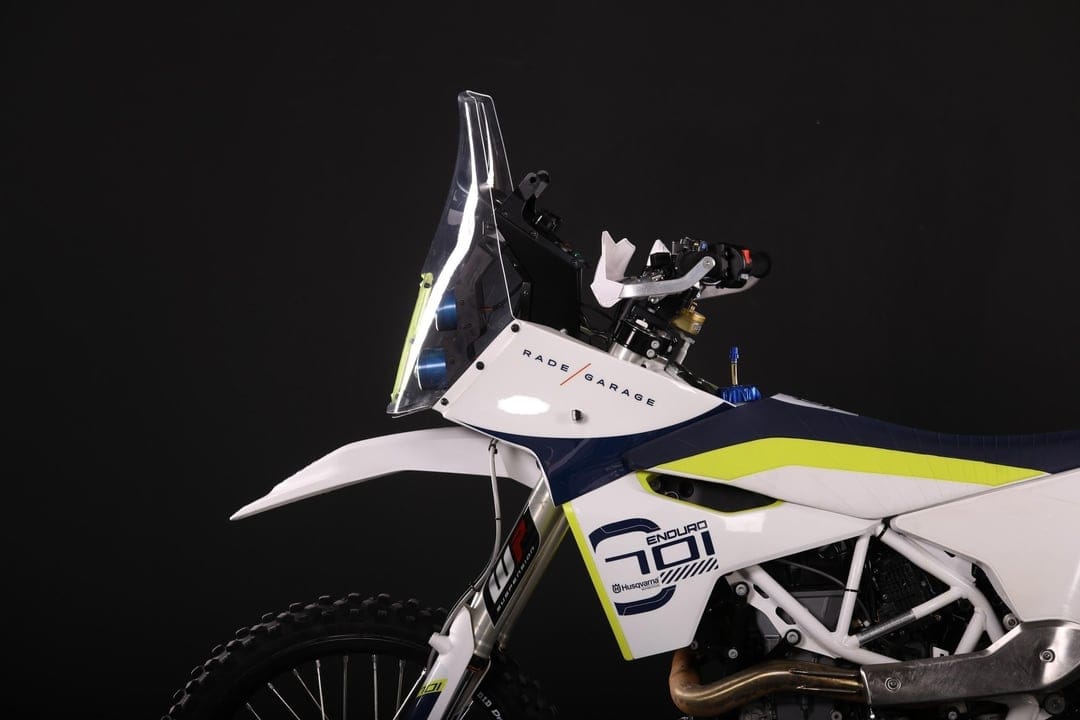 Husqvarna 701 Enduro motorcycle with a Rade Garage rally fairing and windscreen against a black background.