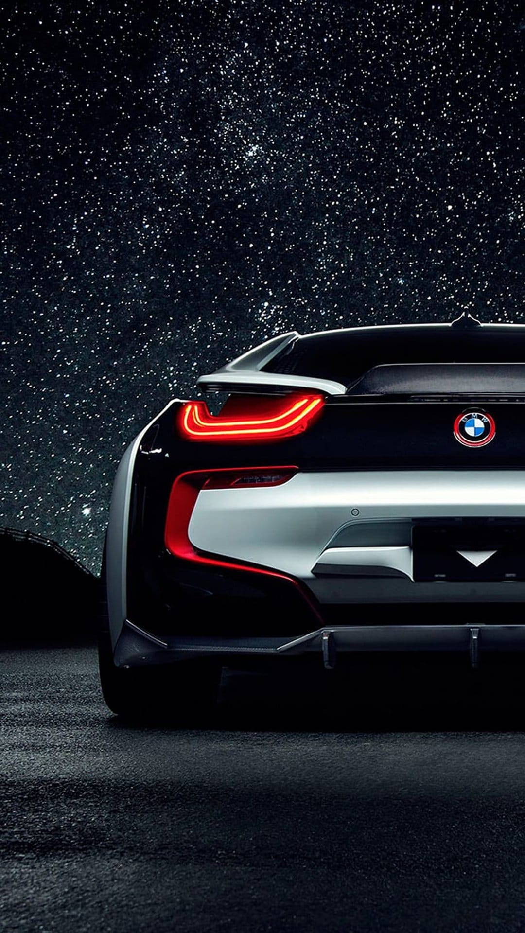 BMW i8 rear taillights glowing red beneath a dense field of twinkling stars and dark blue cosmic nebulas.
