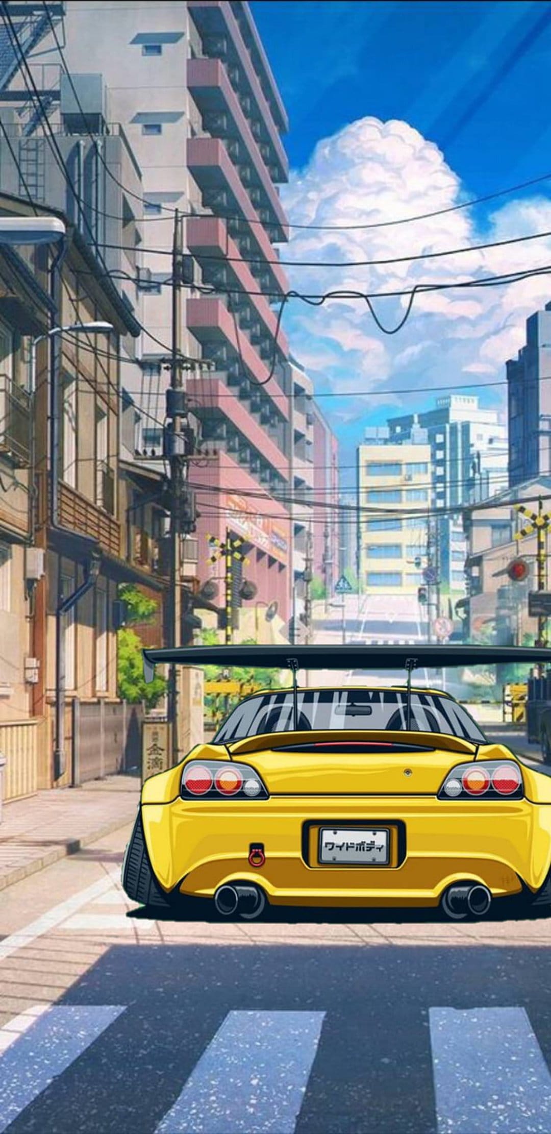 Yellow sports car with a rear wing parked on an urban street with utility poles under a bright blue sky.