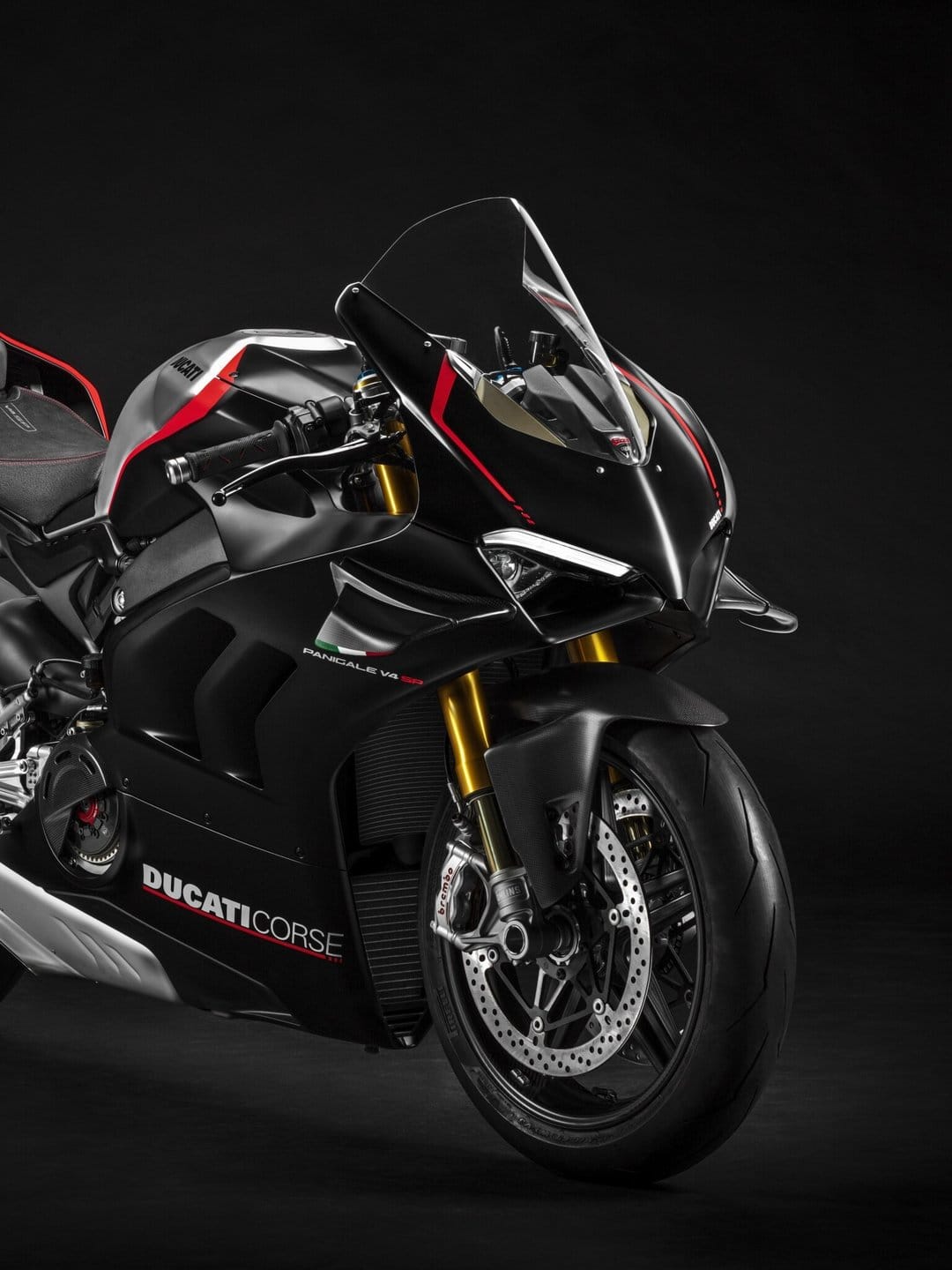 Ducati Panigale V4 SP motorcycle with gold forks and carbon fiber details against a black studio backdrop.