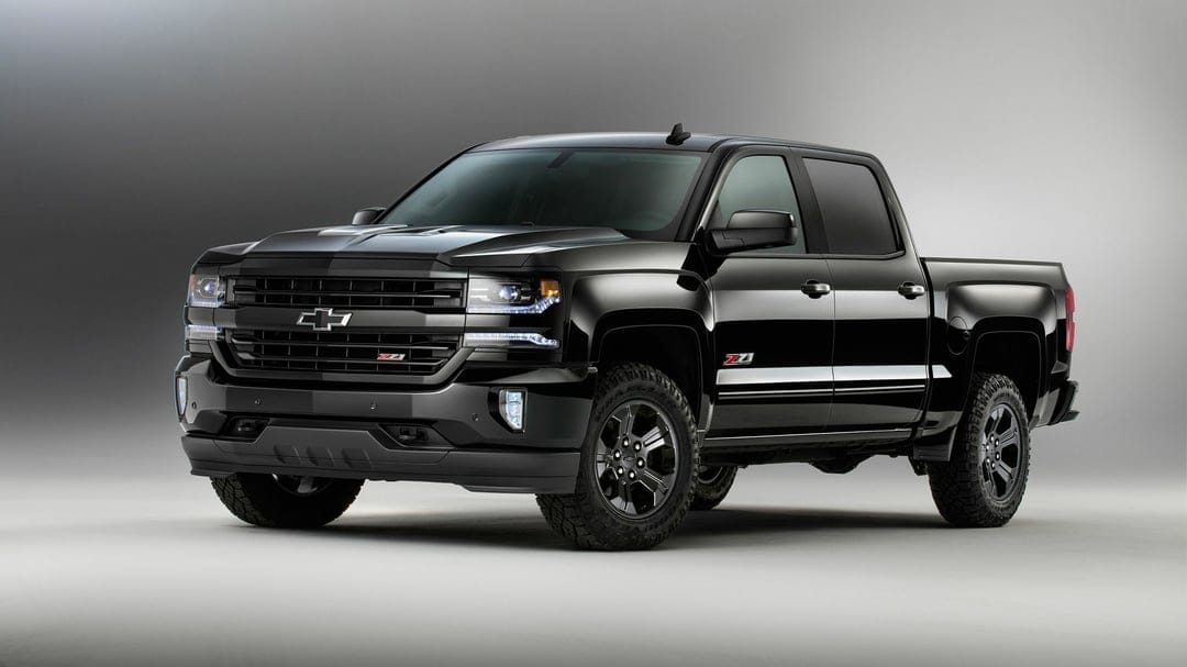 Black Chevrolet Silverado Z71 pickup truck with LED lights and off-road tires in a minimalist gray studio.