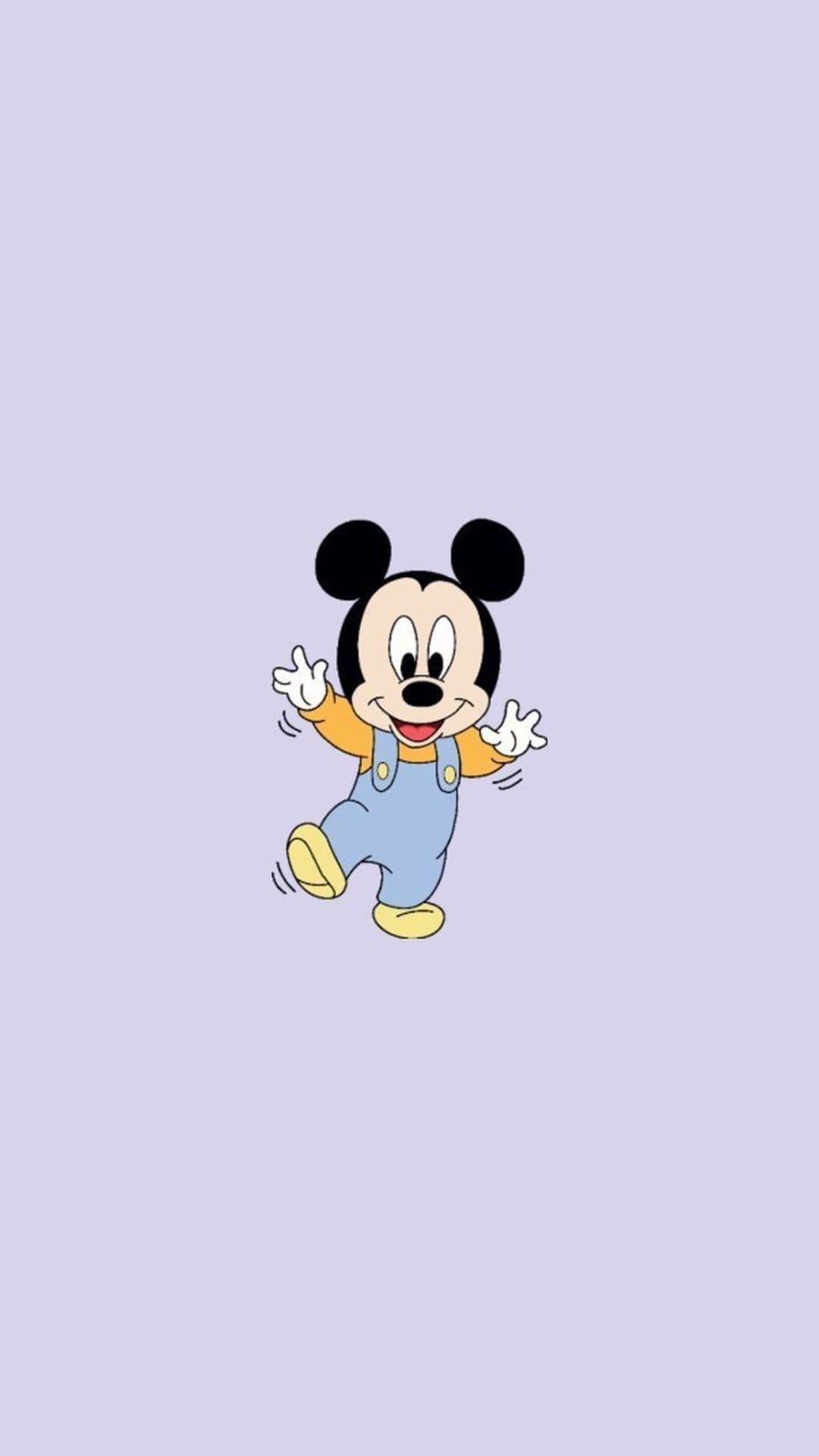Baby Mickey Mouse wears blue overalls and a bright yellow shirt while dancing on a solid lilac background.