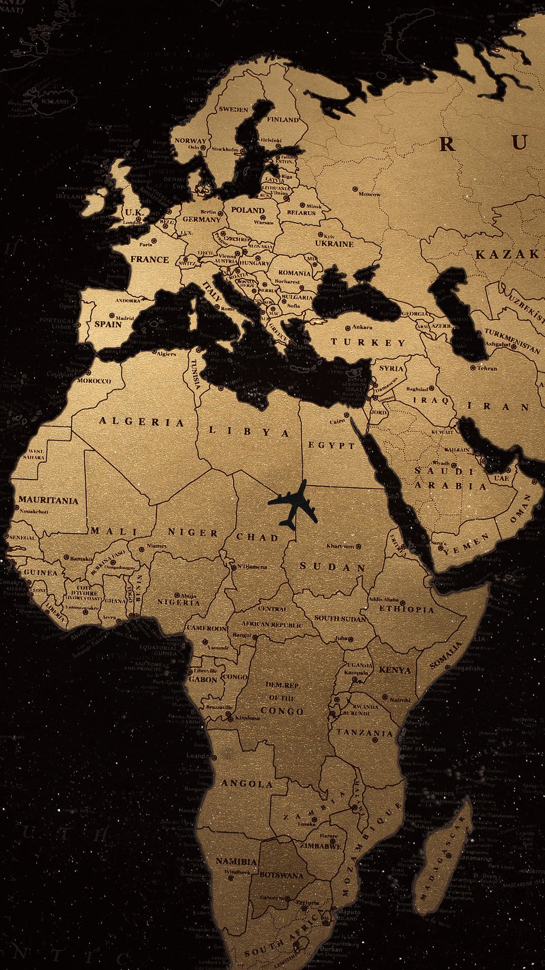 Golden world map with an airplane silhouette flying over the African continent against a dark starry background.