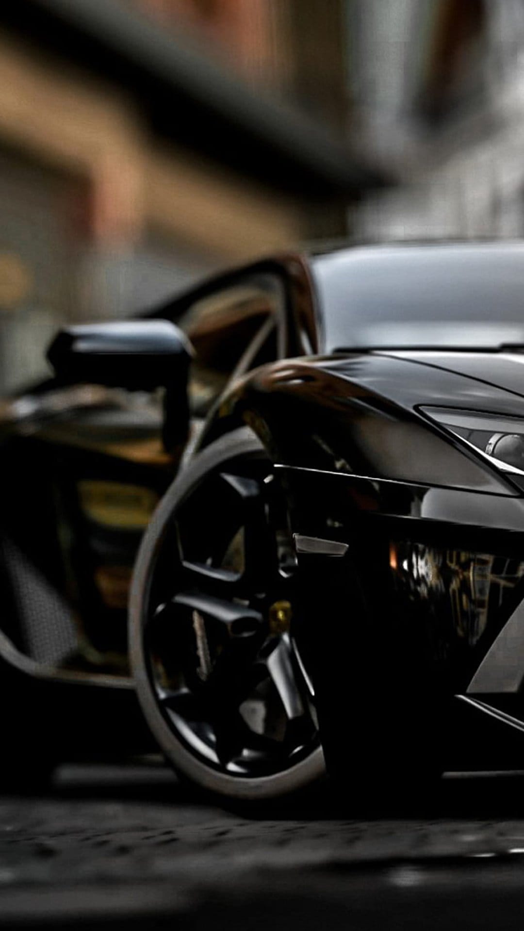 Glossy black sports car fender featuring a sharp headlight and intricate alloy wheel with reflective bodywork.