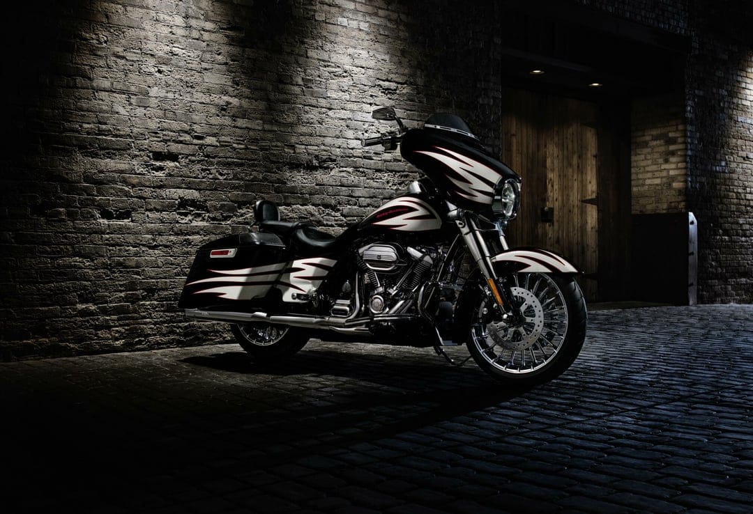 Custom Harley-Davidson motorcycle parked in a dark brick alleyway under dramatic cinematic spotlighting.