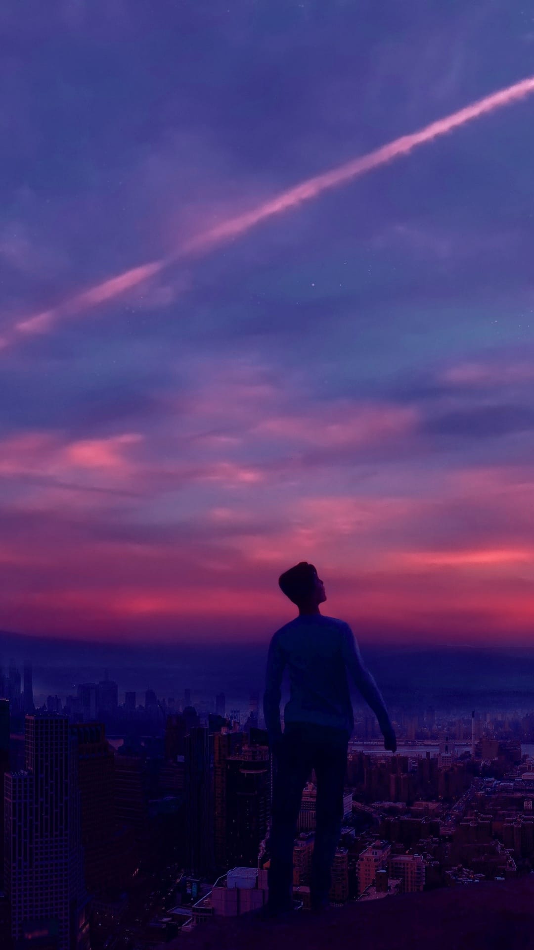 Silhouetted person looking at a purple and pink city skyline with a white contrail streaking across the dusk sky.