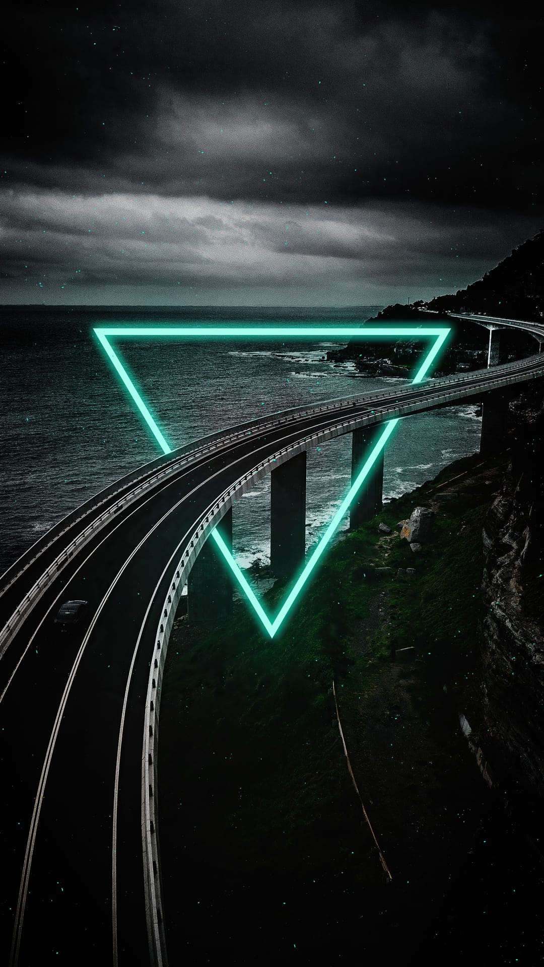 Glowing green neon triangle suspended over a dark coastal highway bridge with crashing ocean waves below.