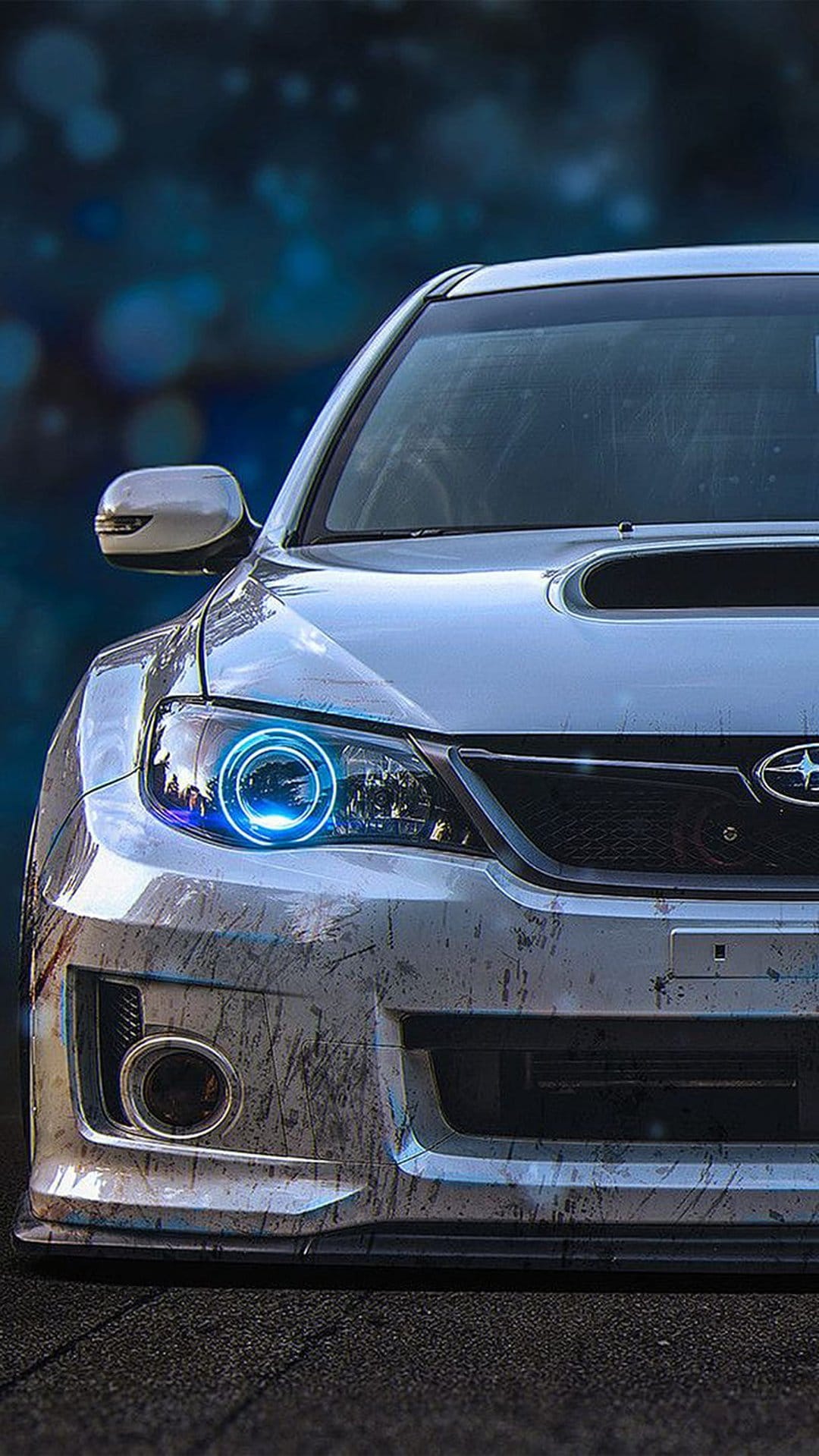 Subaru WRX STI headlight with a bright blue halo ring, textured grille, and hood scoop in a close-up shot.