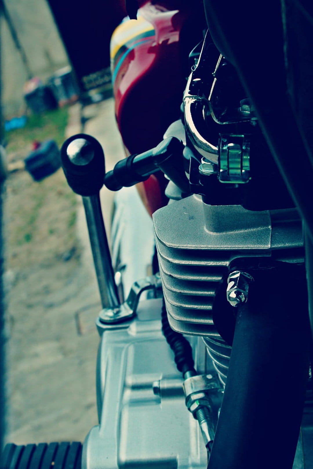 Motorcycle engine block with chrome cooling fins and handlebar controls featuring a weathered vintage patina.