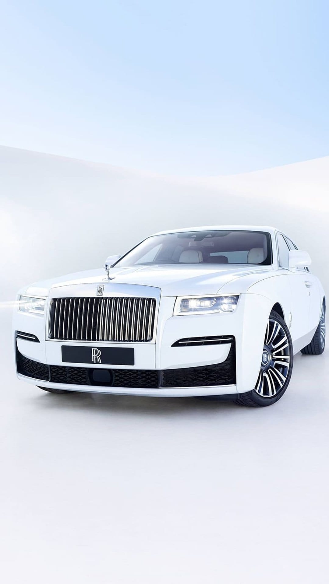 White Rolls-Royce Ghost sedan features a chrome grille and Spirit of Ecstasy ornament on a light background.