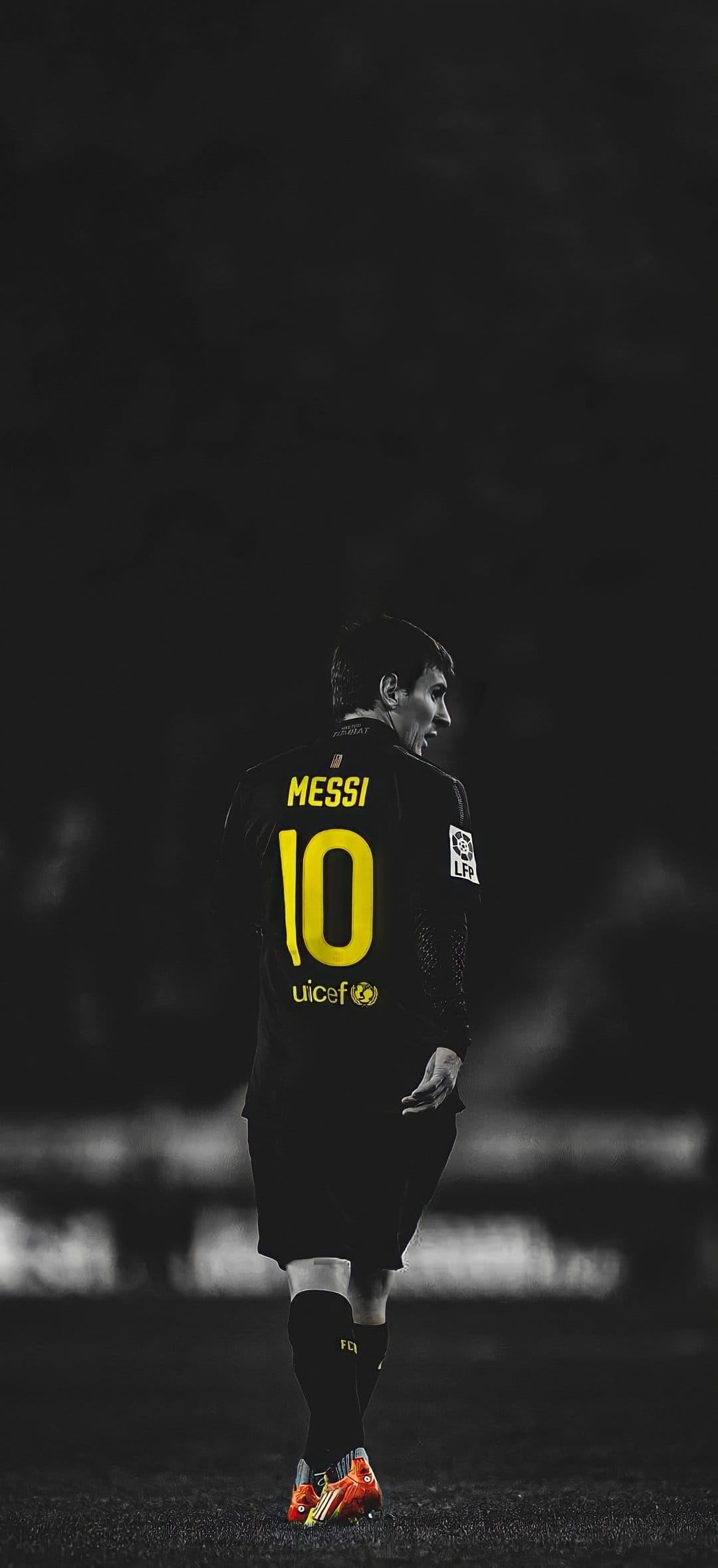 Lionel Messi in a number 10 jersey and orange boots stands on grass in a desaturated, high-contrast style.