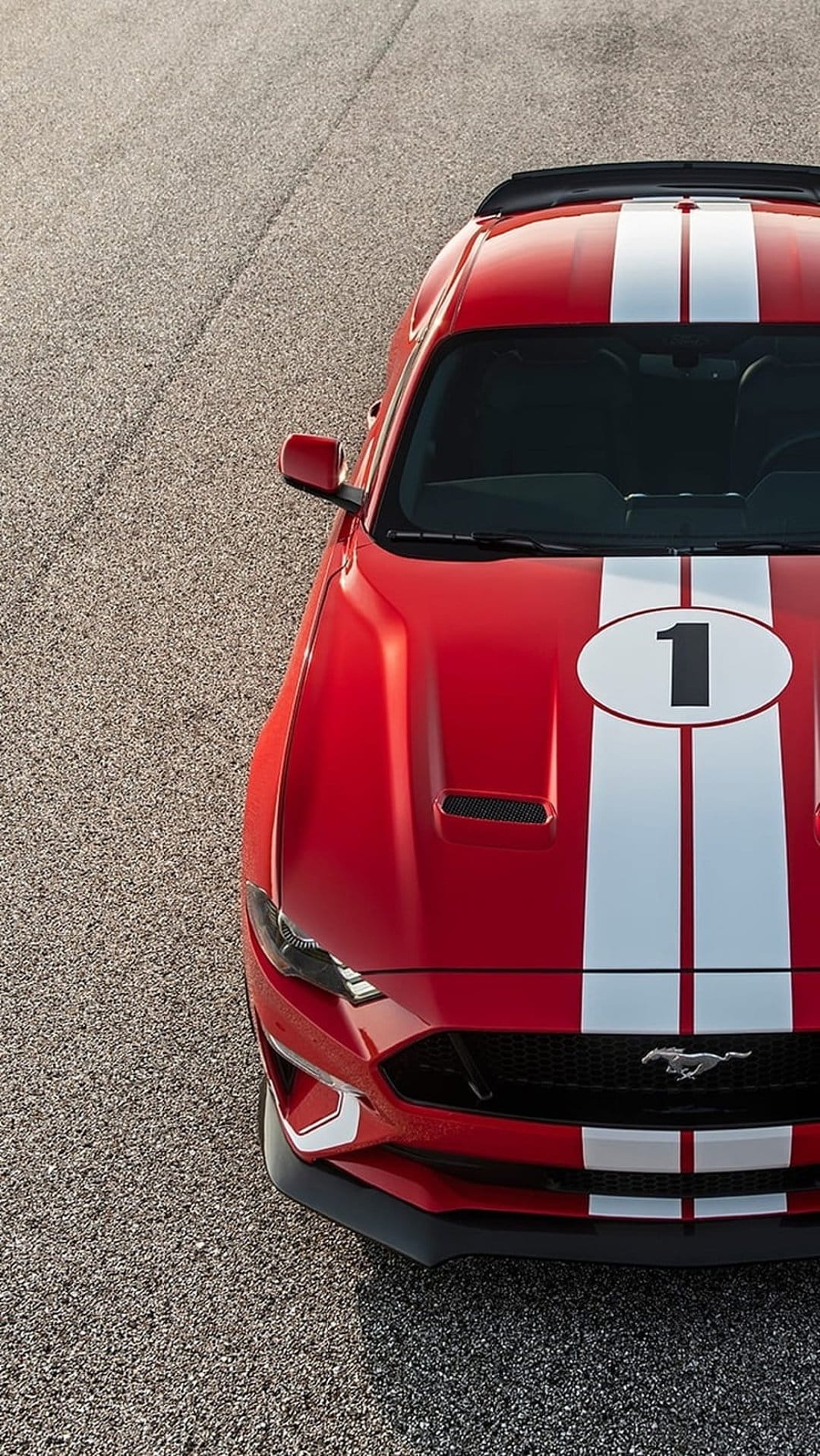 Red Ford Mustang features white racing stripes and a number 1 emblem on the hood against textured asphalt.