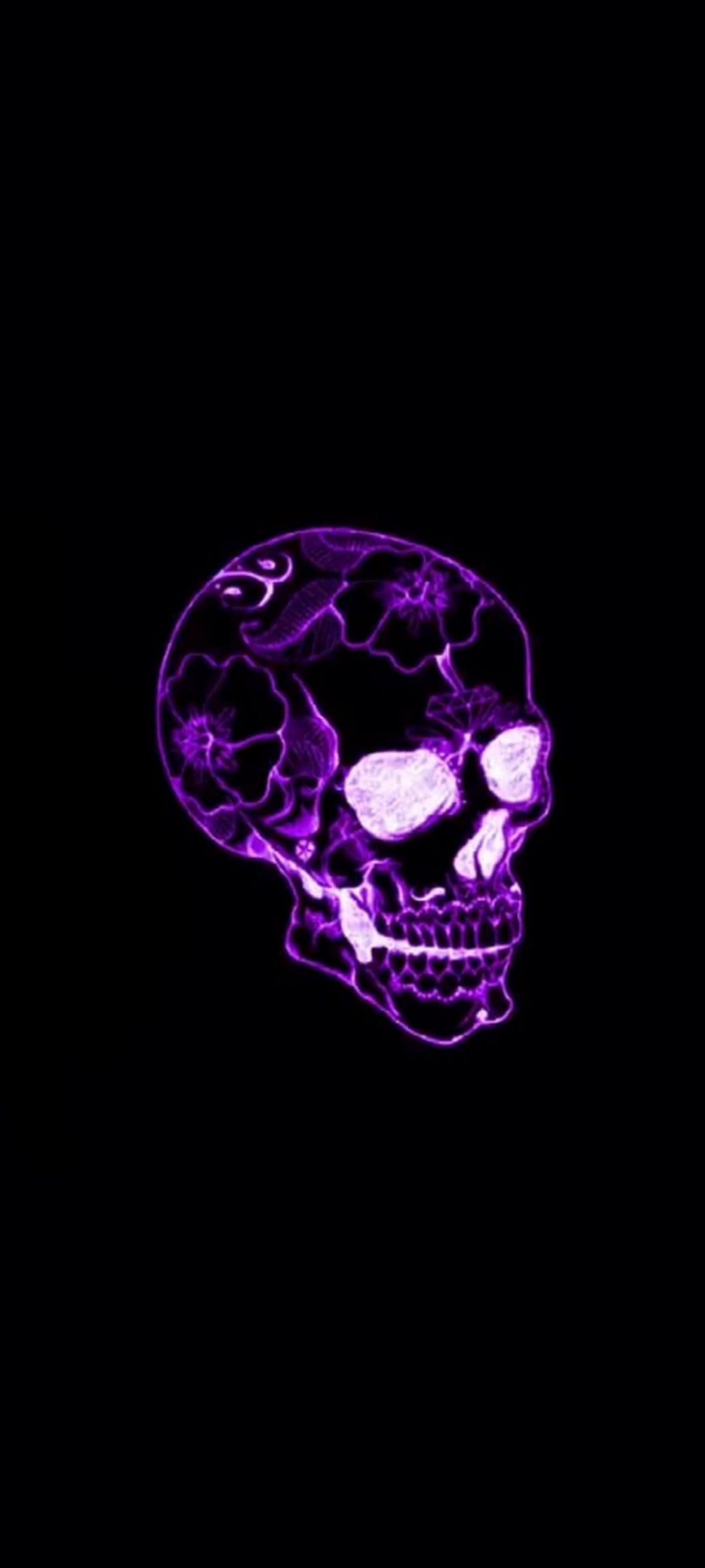 Human skull with glowing purple neon floral patterns inside the bone structure against a dark black background.