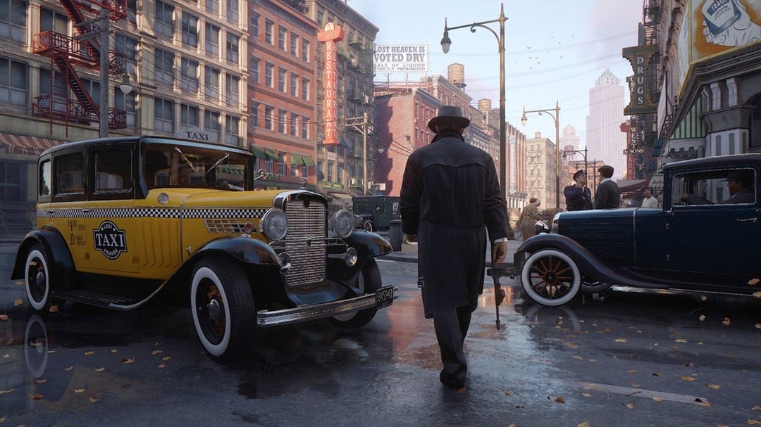 Man in a fedora walking on a wet 1930s street between a yellow taxi and a blue classic car during the daytime.