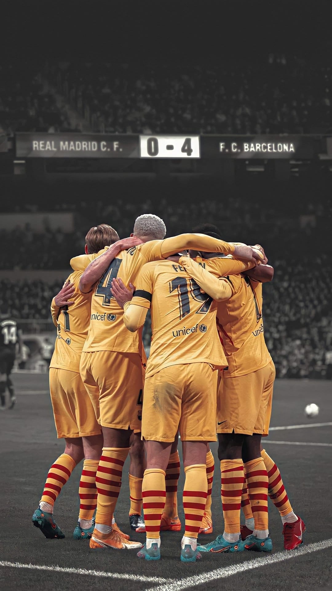 Barcelona players in blue and red jerseys celebrate on a green pitch with a scoreboard showing 0-4 in the background