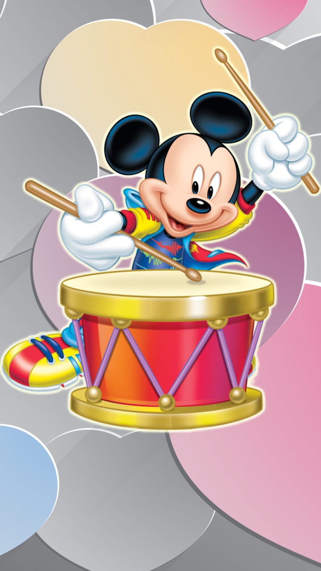 Mickey Mouse smiles while drumming with sticks on a striped drum surrounded by soft gray and pastel circular shapes.