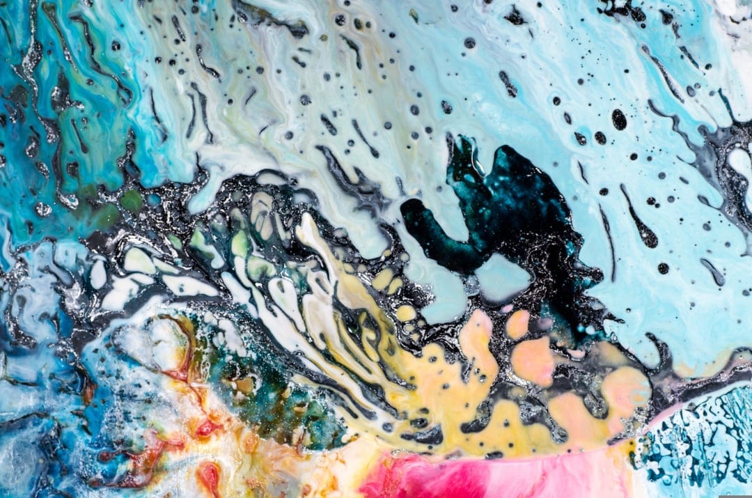 Turquoise and pink liquid swirls intertwine with deep black ink veins in a high-contrast abstract marble pattern.