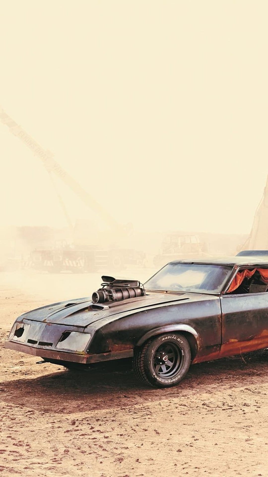 Black Interceptor car with a hood supercharger stands on cracked desert earth under a hazy, orange-tinted sky.