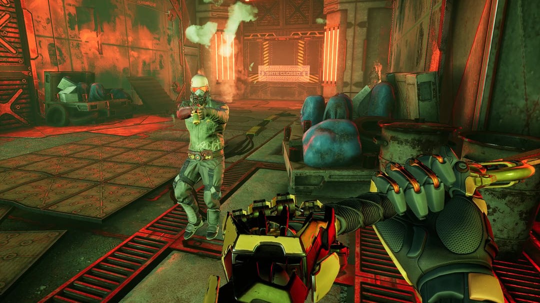 First-person perspective of mechanical hands facing an armed enemy in a red-lit industrial hangar.