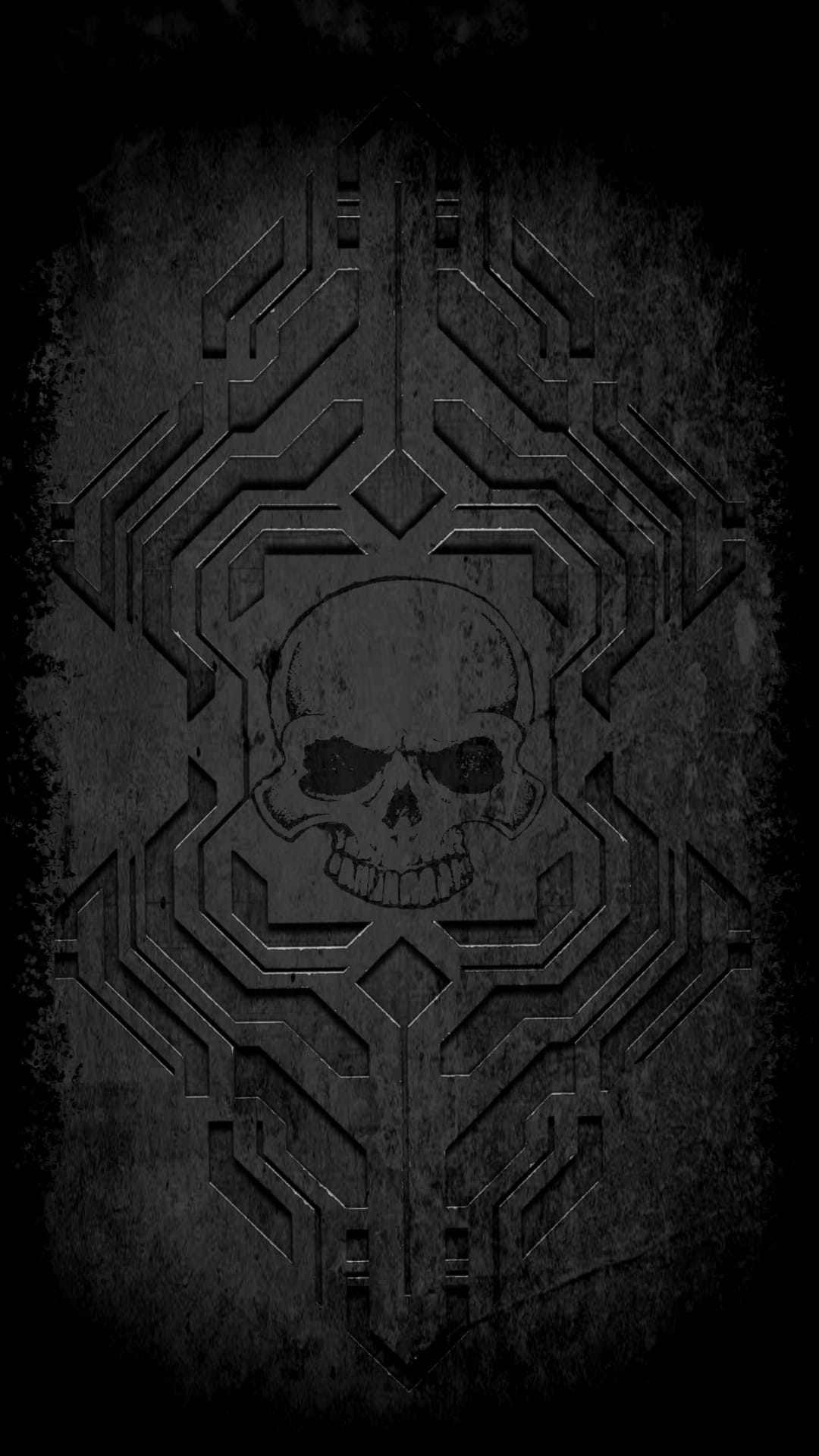 Metallic skull centered inside complex geometric carvings with a distressed monochromatic stone texture.