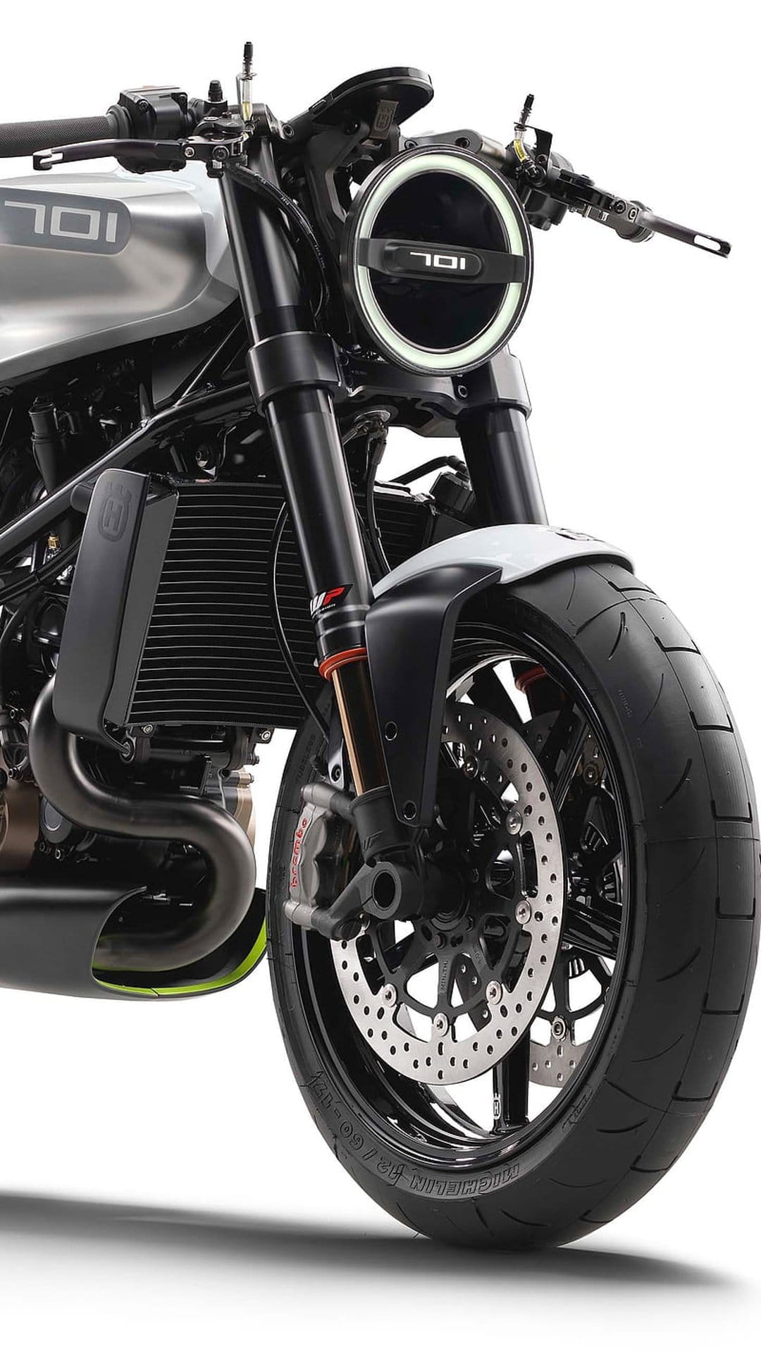 Husqvarna 701 Vitpilen front view showing a circular LED headlight, black forks, and rugged front tire.