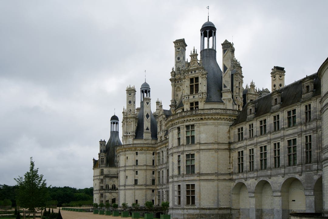 Château de Chambord displays intricate stone towers and a wide Renaissance facade across a manicured lawn.