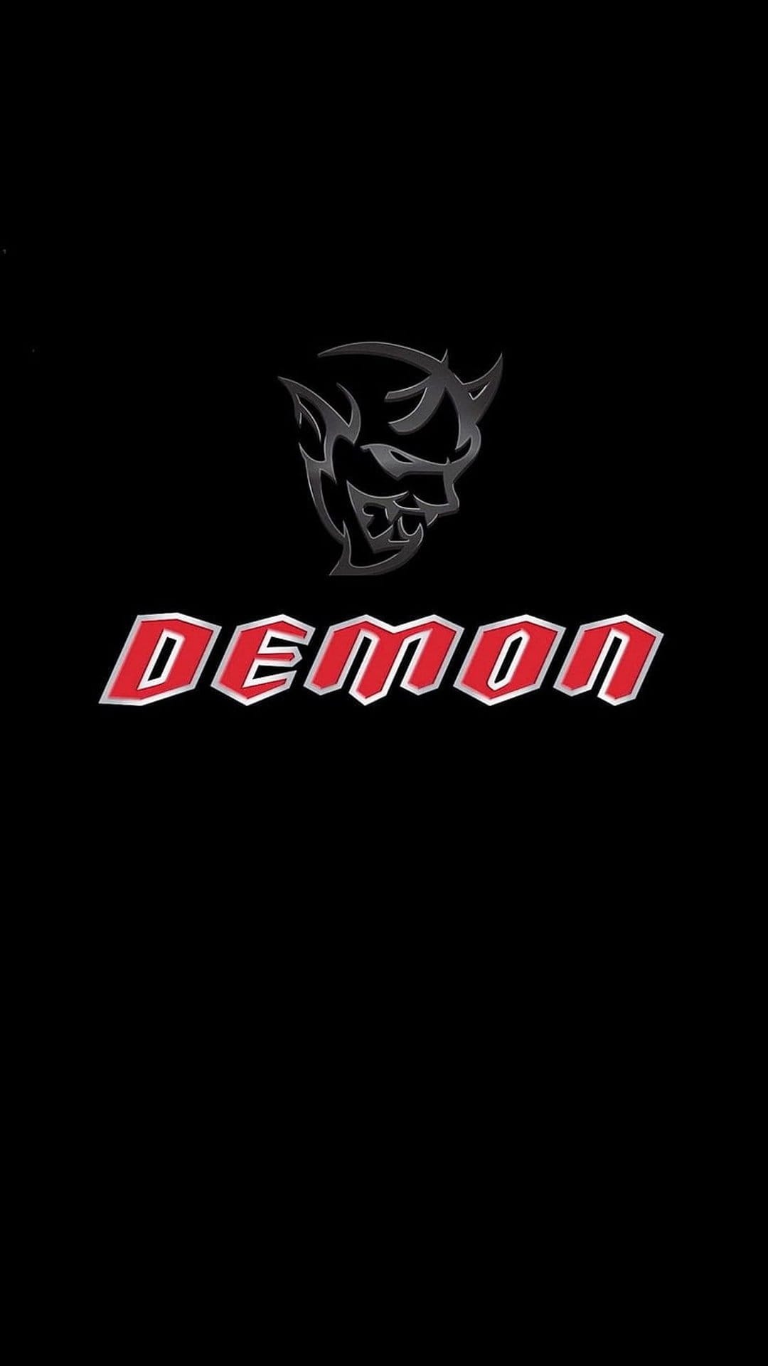 Dodge Demon emblem with a silver face and red stylized text centered on a solid matte black background.