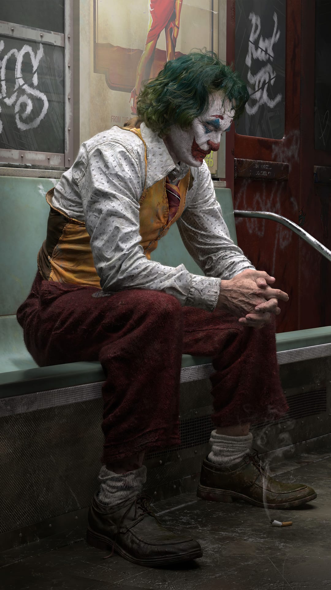 Arthur Fleck in clown makeup sits on a subway seat with green hair and a mustard vest next to urban graffiti.
