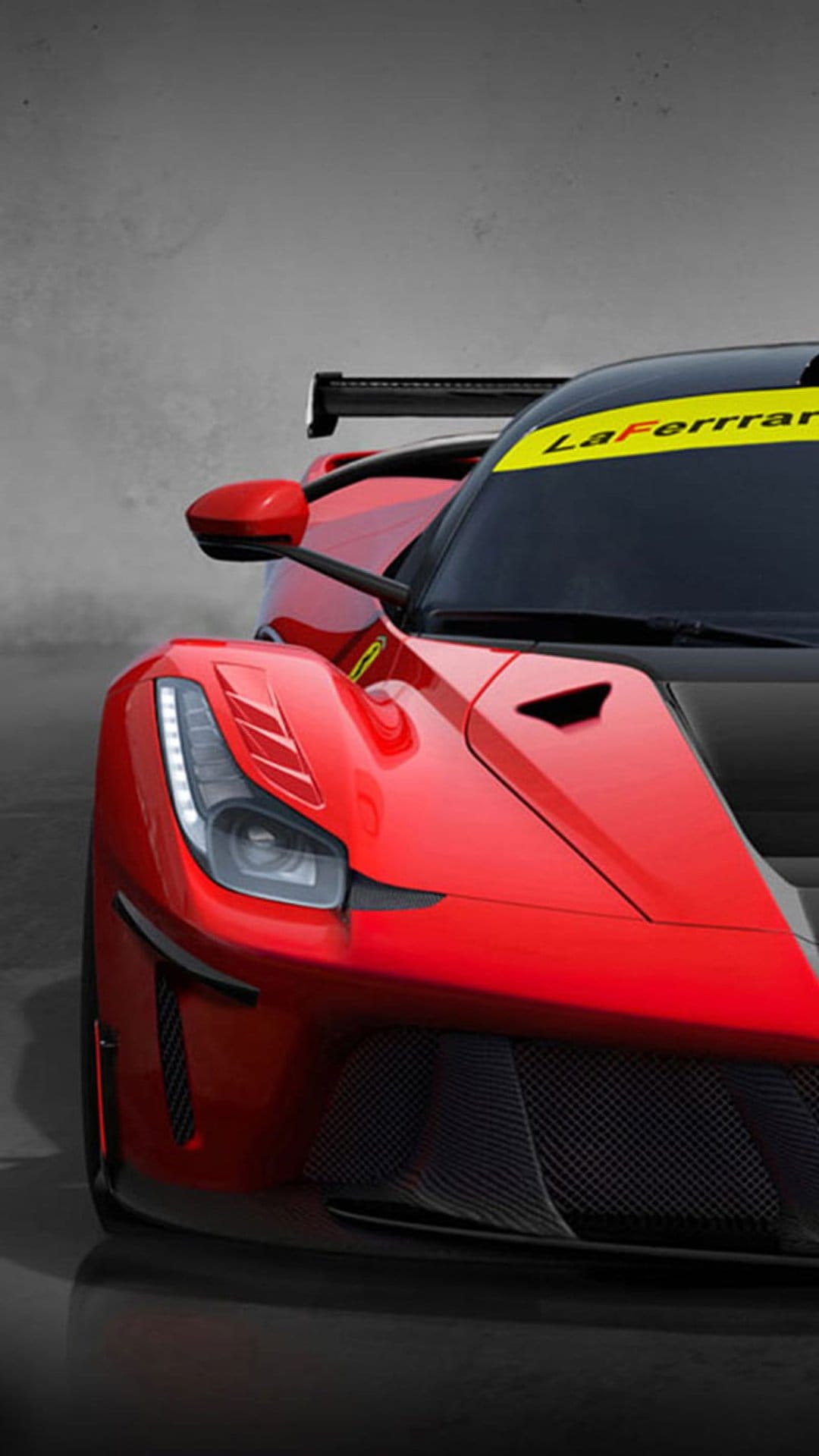 Red Ferrari LaFerrari race car showing aggressive headlights, a black grille, and a yellow windshield banner.