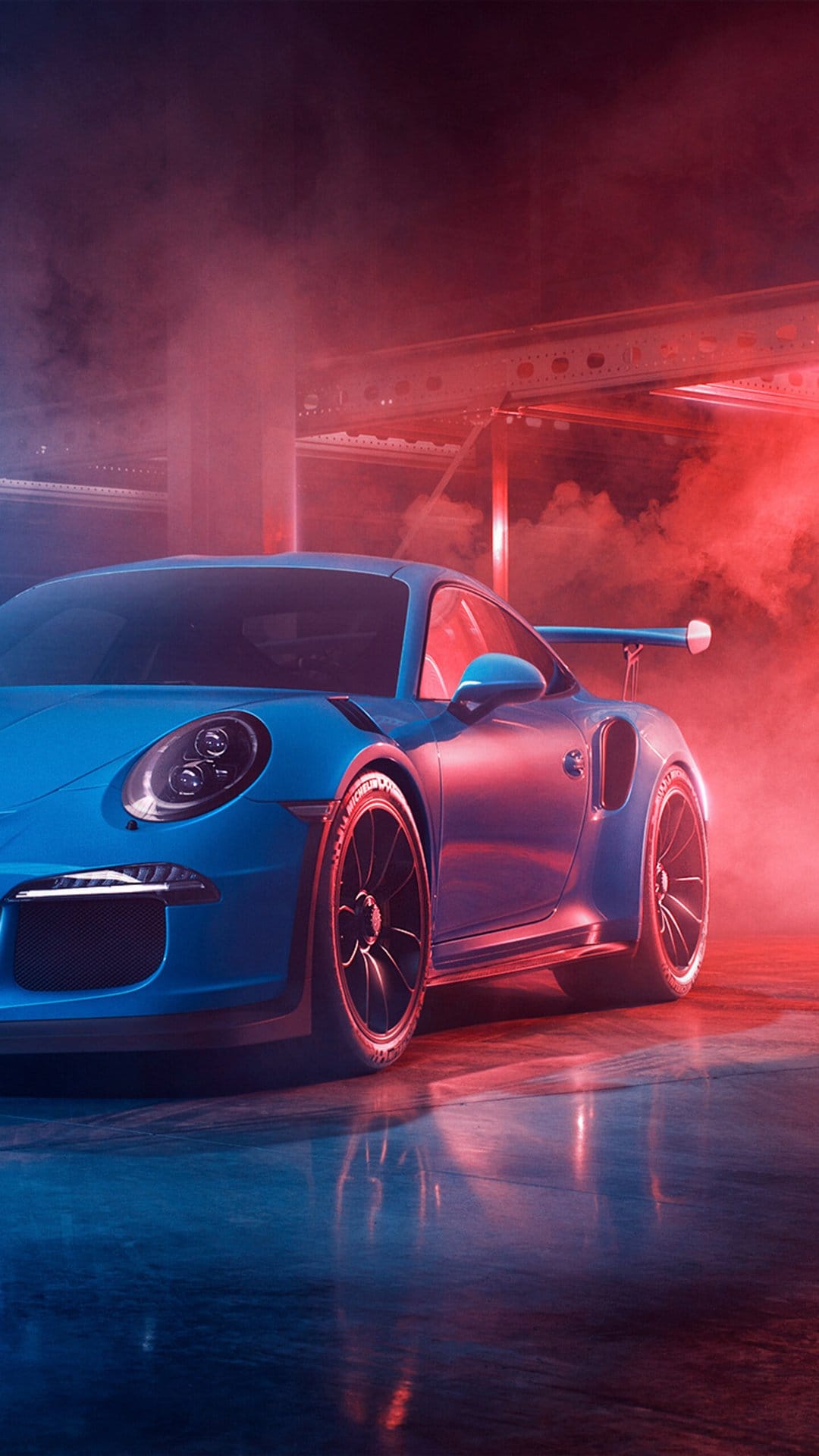 Blue Porsche 911 GT3 RS in a smoky garage with vibrant red and blue neon lighting and a large rear wing.
