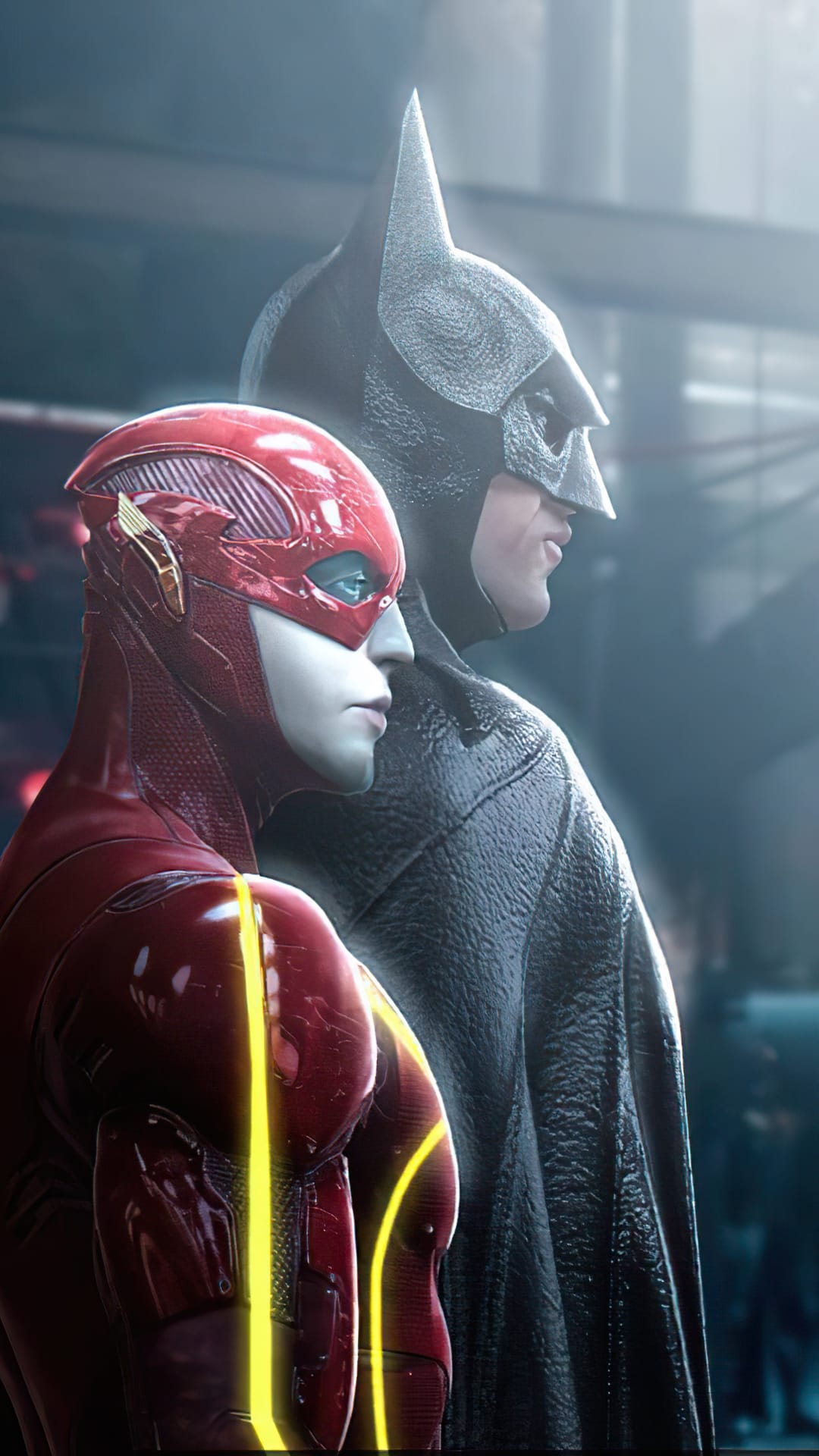 The Flash in a red suit stands before a cowled Batman in dark armor within a cinematic, shadowed environment.