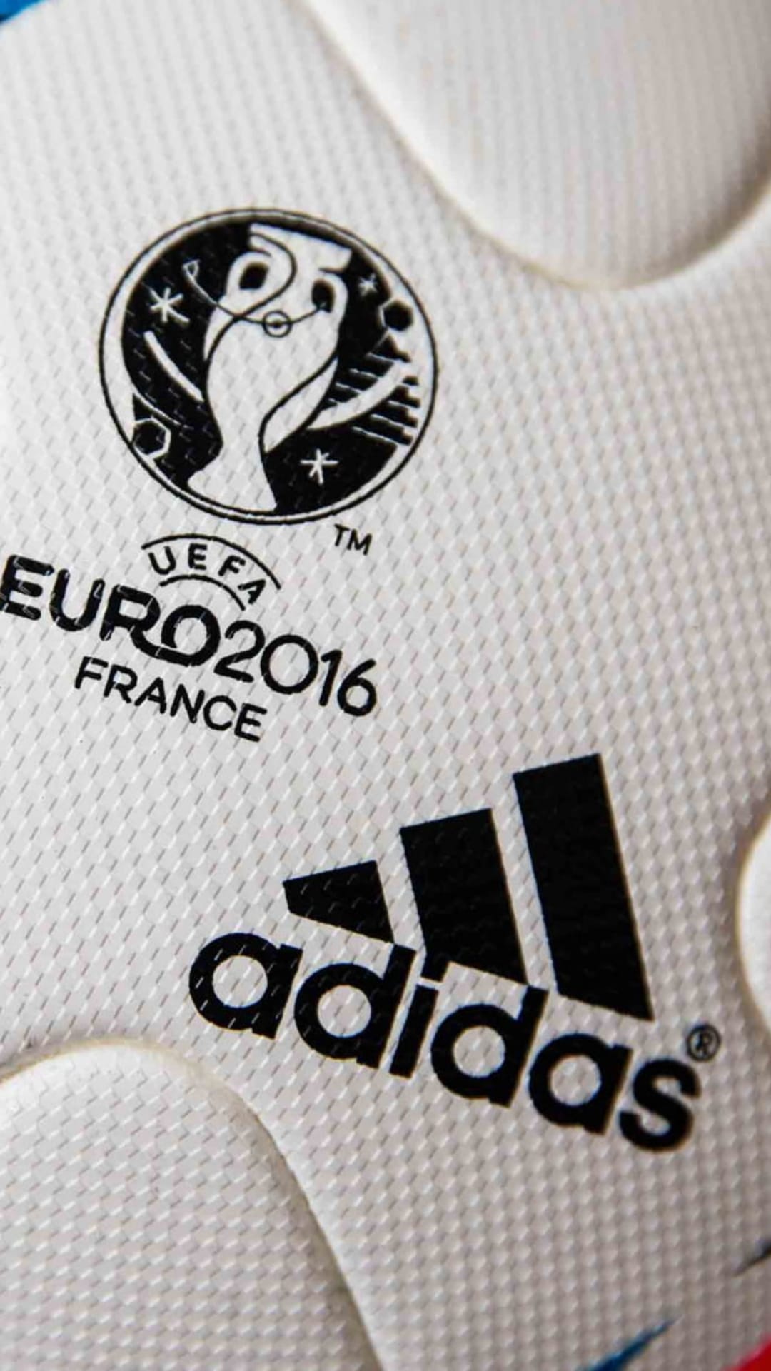 Official Adidas Euro 2016 football with colorful tournament logos rests on a white textured synthetic surface.